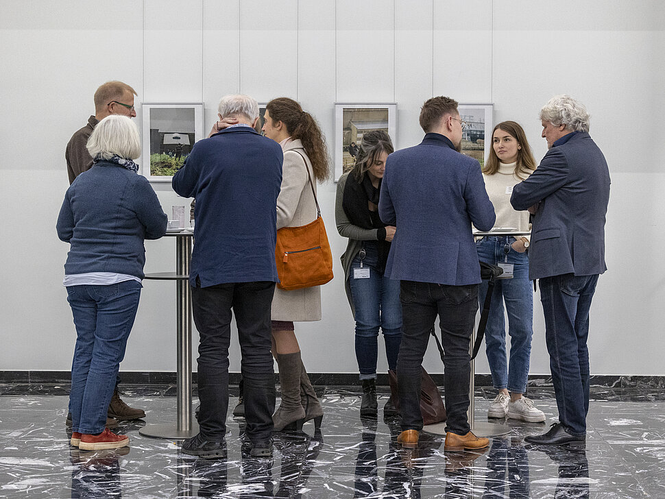 Zwei Menschengruppe um jeweils einen Stehtisch