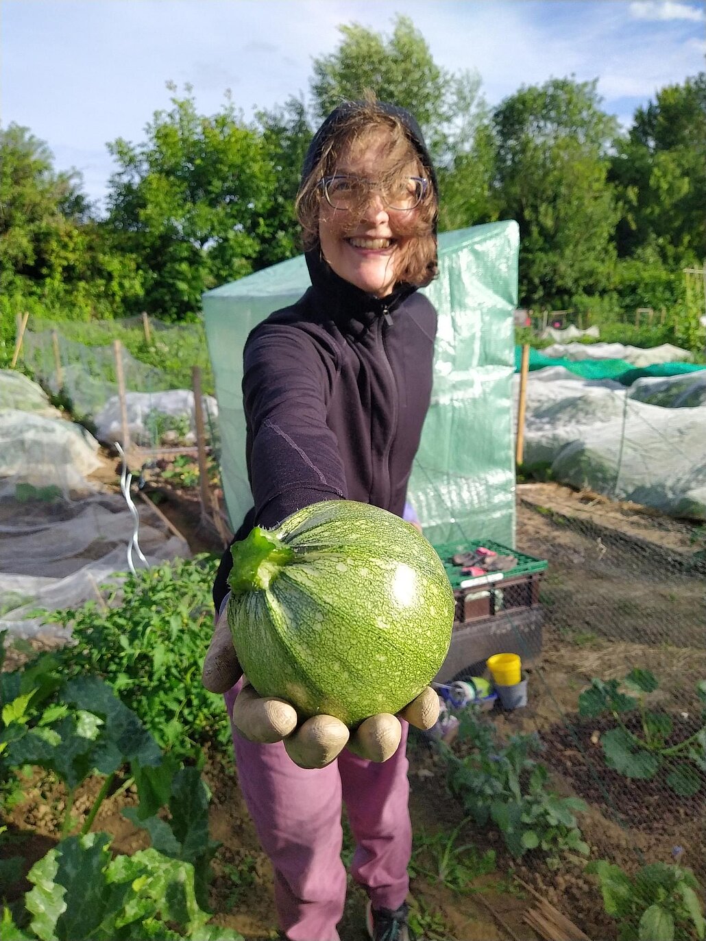 Eine Gärtnerin, die ihre Zucchini präsentiert