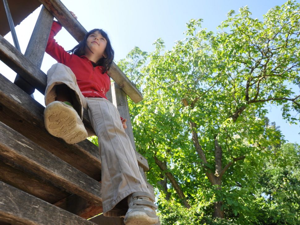 Mädchen auf Klettergerüst am Waldspielplatz