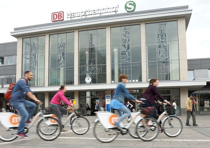Radfahrerinnen und Radfahrer auf Rädern von metropolradruhr vor Bahnhofsgebäude.                     