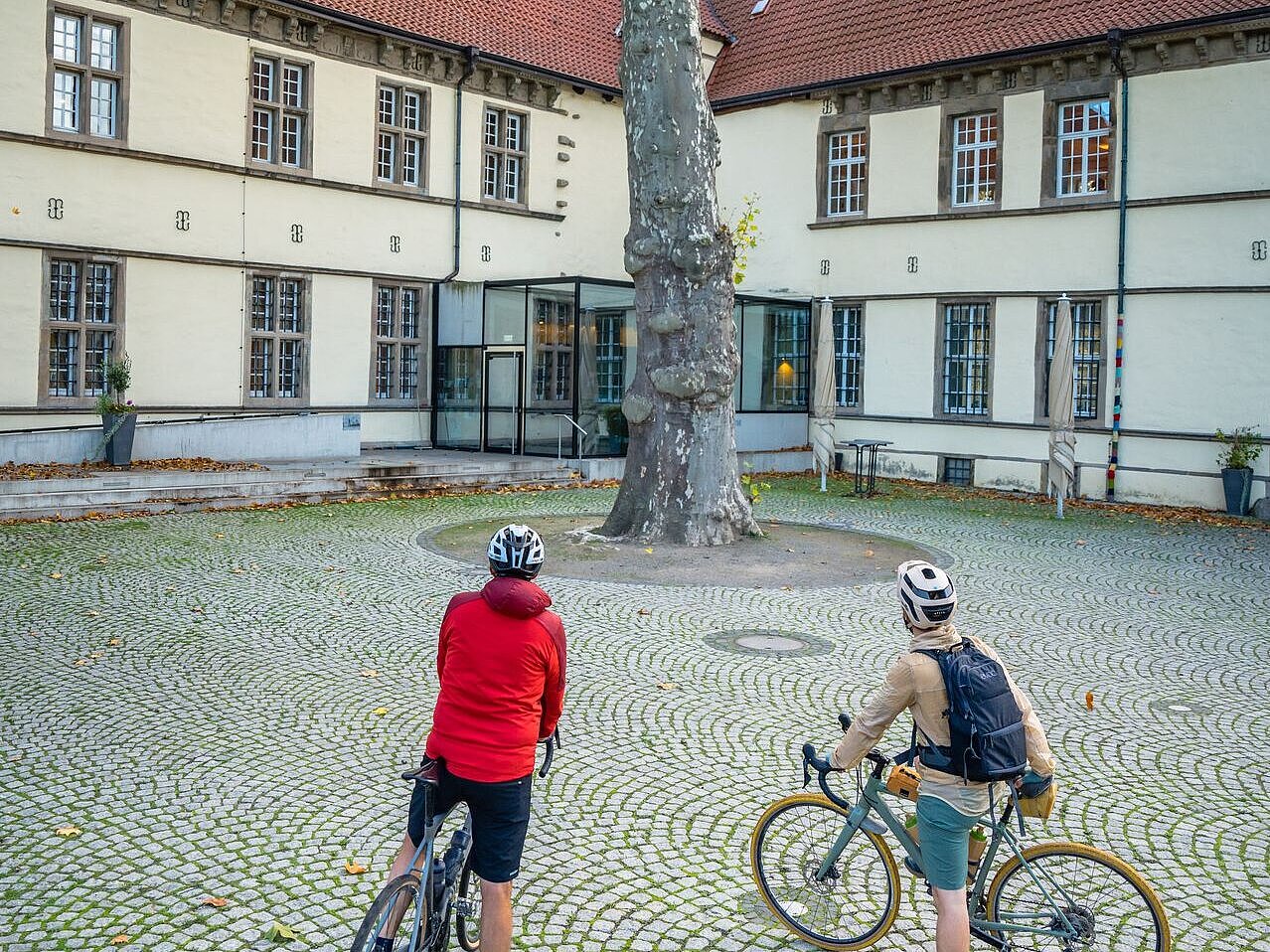 Zwei Radfahrende stehen vor dem Schloss Strünkede.