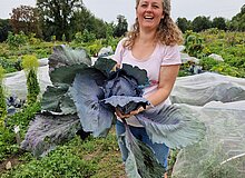 Eine Gärtnerin, die ihren Rotkohl präsentiert