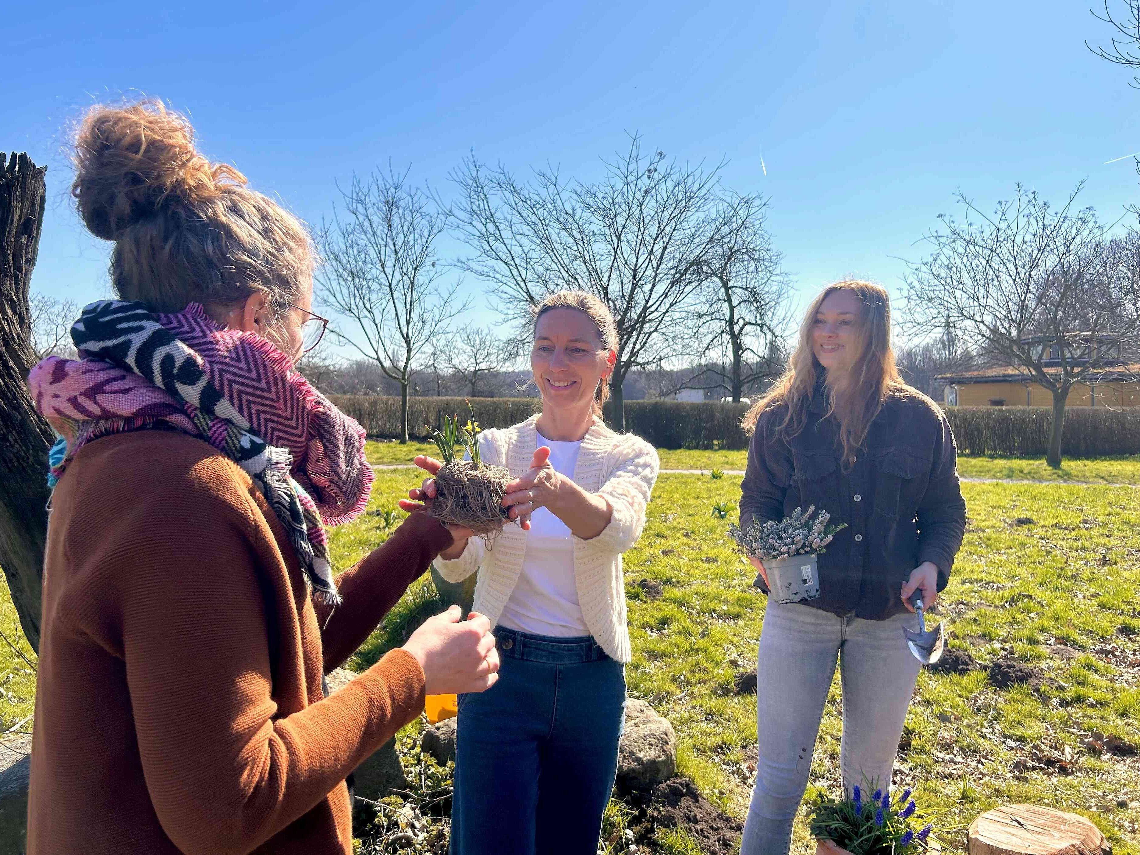 Drei Personen tauschen Pflanzen