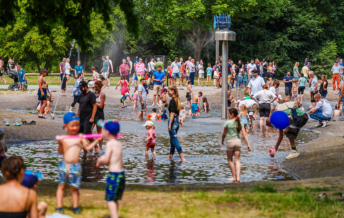 Kinder plantschen im Wasser.
