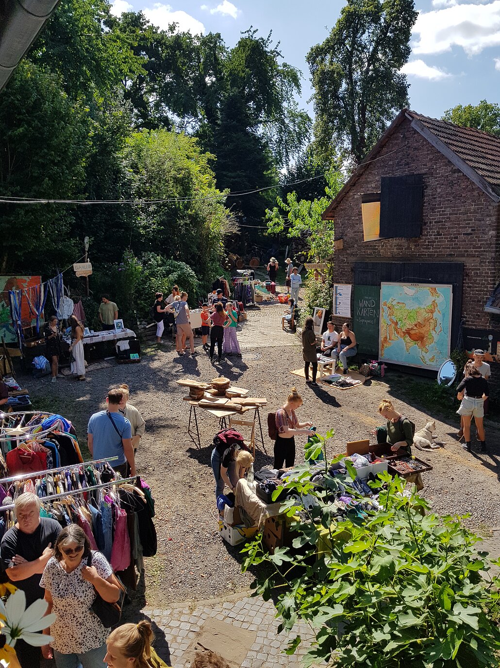 Ein Flohmarkt auf dem Hof mit Kleidungs- und Handwerkständen. 