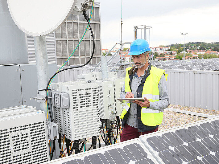 Ingenieur auf einem Gebäudedach mit Solarpanels