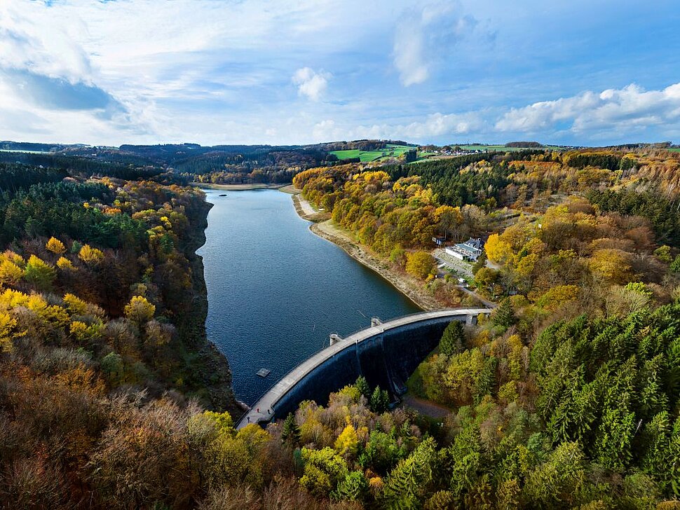 Die Glörtalsperre bei Breckerfeld im Ennepe-Ruhr-Kreis im Herbst aus der Luft gesehen, im Vordergrund die Staumauer.