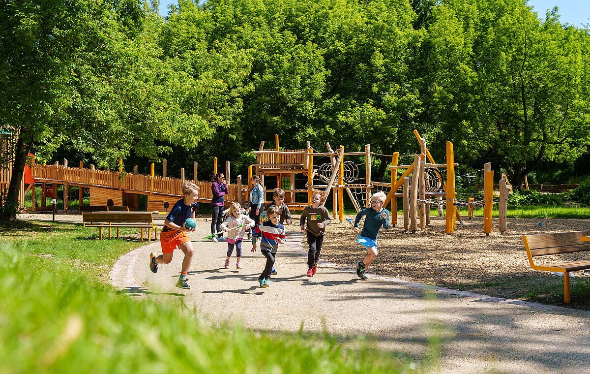 Gruppe von Kindern rennen entlang eines Klettergerüstes.