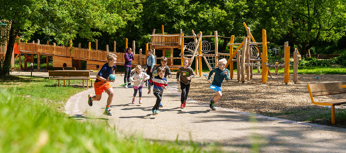 Gruppe von Kindern rennen entlang eines Klettergerüstes.