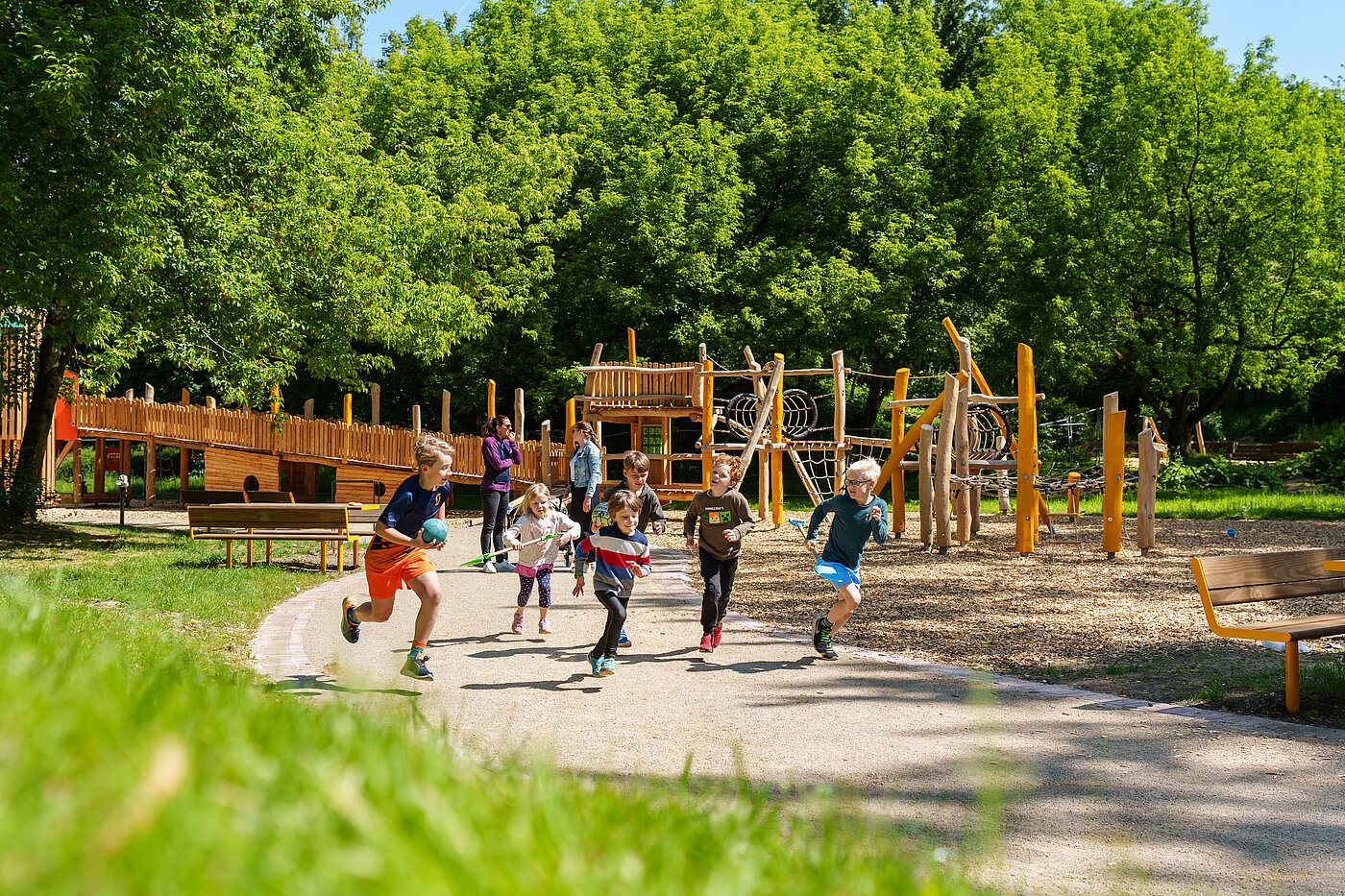 Gruppe von Kindern rennen entlang eines Klettergerüstes.