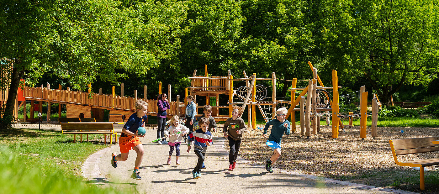 Gruppe von Kindern rennen entlang eines Klettergerüstes.