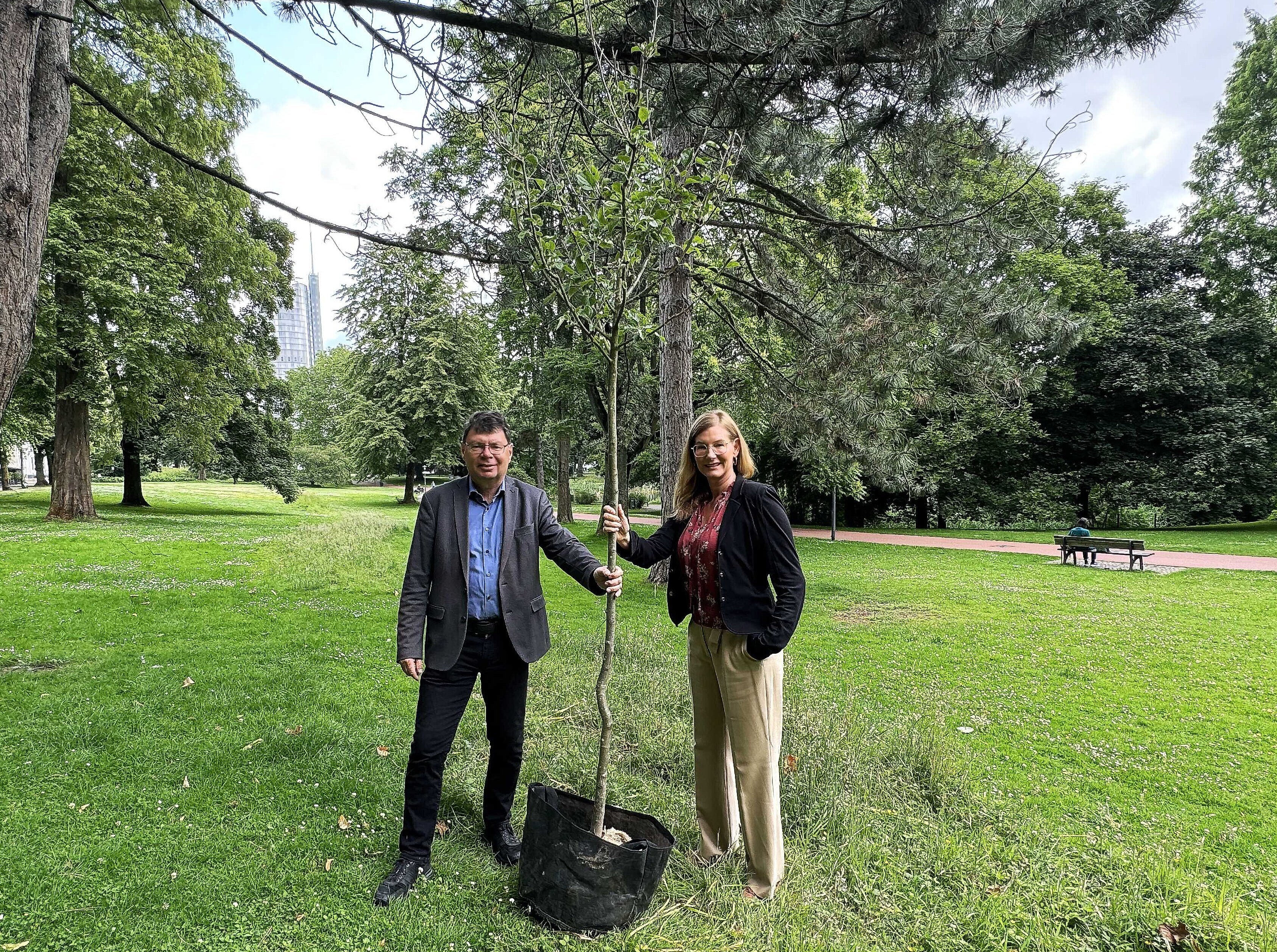 Nina Frense, RVR-Beigeordnete für Umwelt und Grüne Infrastruktur (rechts) und Horst Fischer, Geschäftsführer der IGA Metropole Ruhr 2027 gGmbH, halten gemeinsam einen Baum in der Hand.