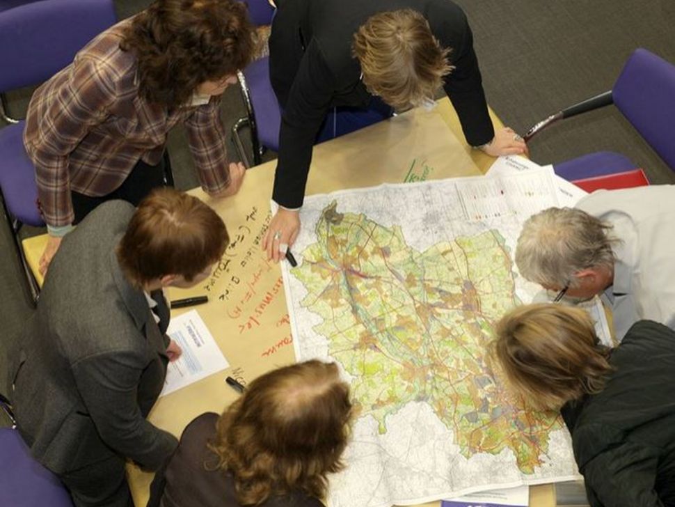 Aus der Vogelperspektive: Gruppe betrachtet einen Plan.