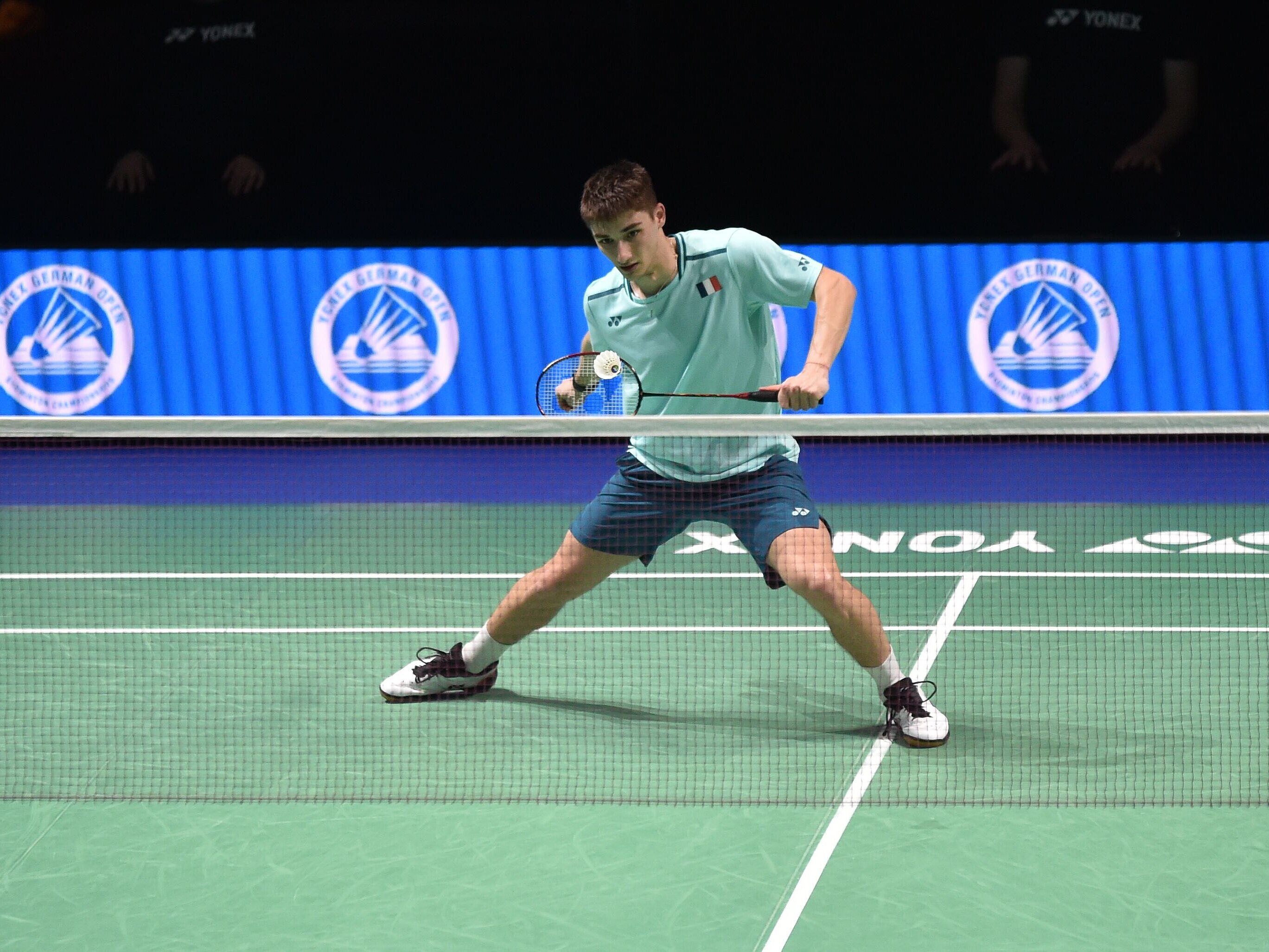 Badmintonspieler auf Spielfeld.