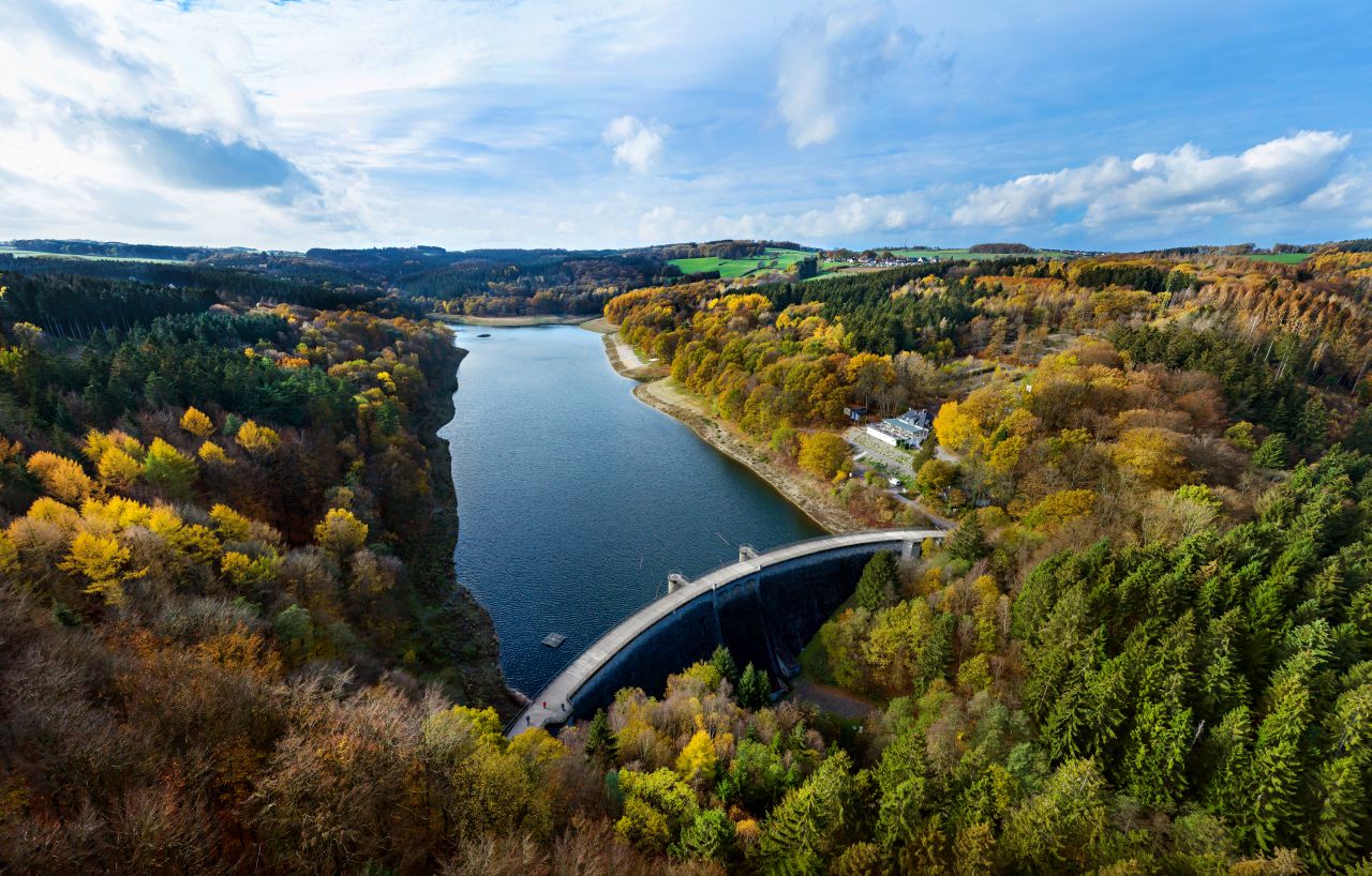Die Glörtalsperre bei Breckerfeld im Ennepe-Ruhr-Kreis im Herbst aus der Luft gesehen, im Vordergrund die Staumauer.
