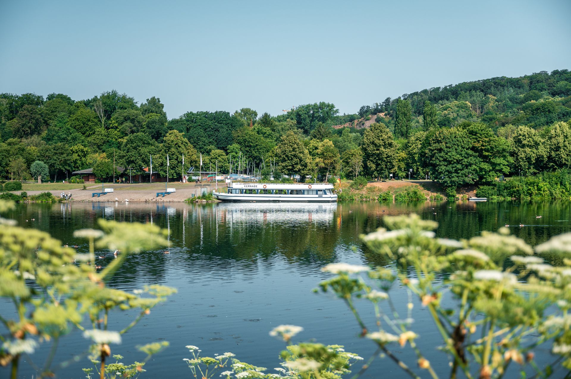  Die MS Kemnade in Bochum steht auf dem Wasser umringt von viel grüner Natur. 