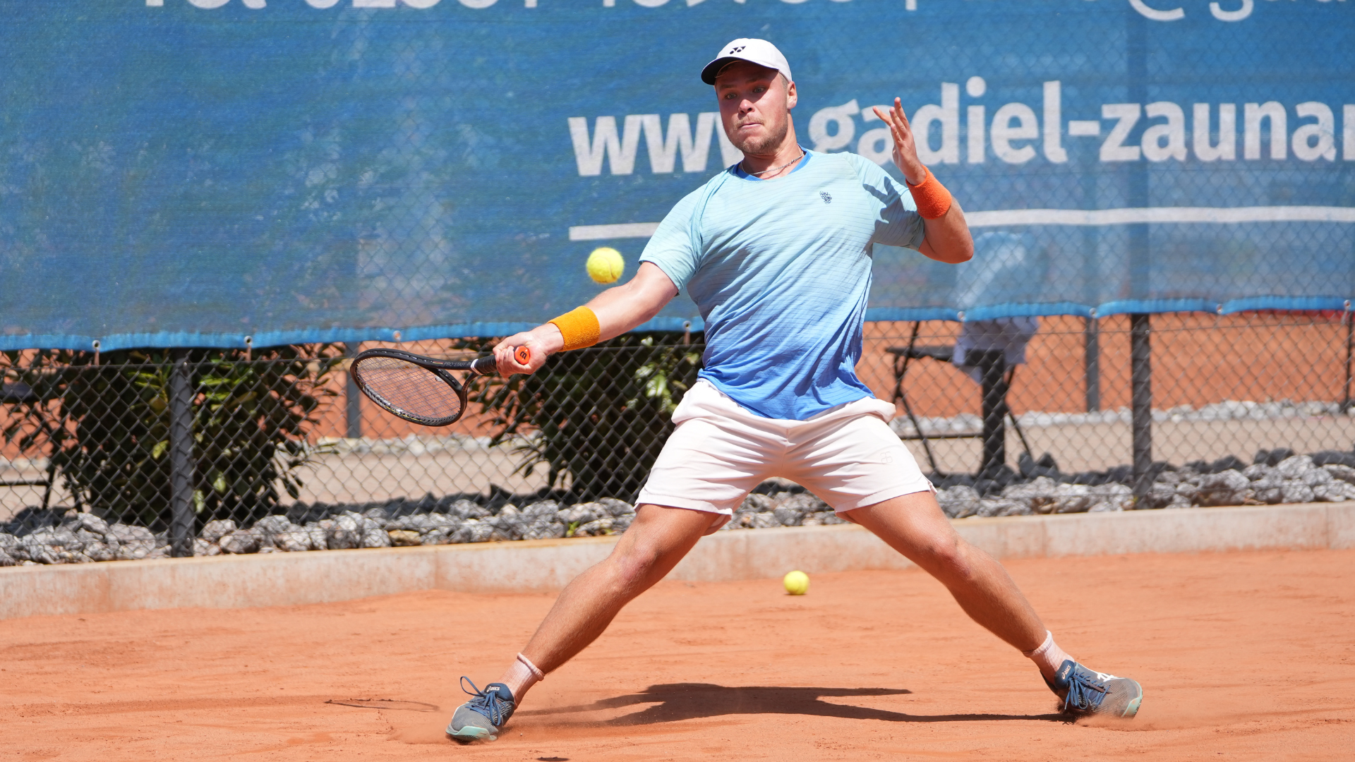 Tennisspieler schlägt einen Ball. 