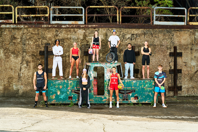 Verschiedene Sportler und Sportlerinnen auf einem großen Siegerpodest