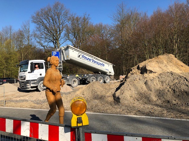 Holzfigur vor der Baustelle zur Waldpromenade.