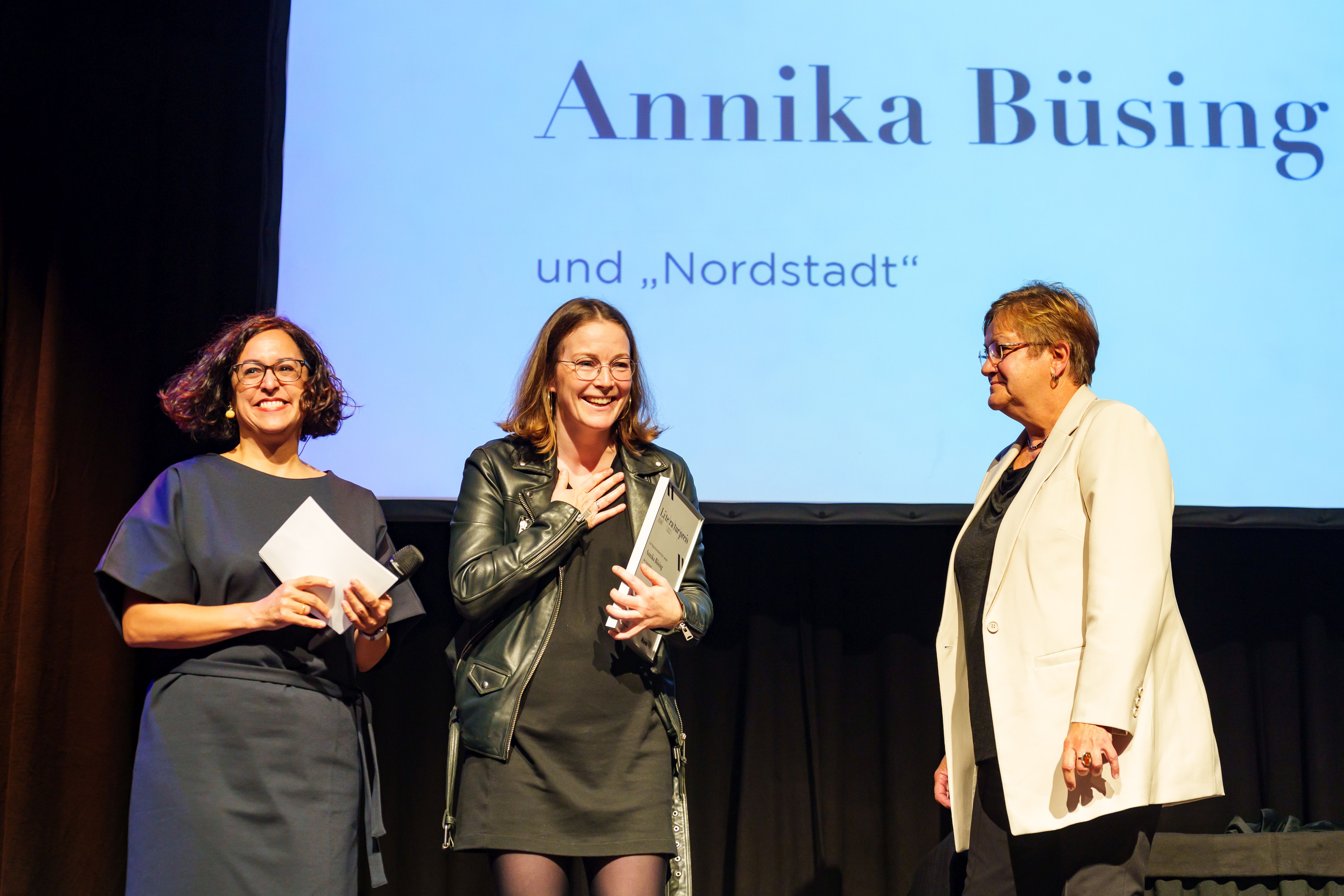 Hauptpreisträgerin Annika Büsing freut sich über ihre Auszeichung zusammen mit Moderatorin Elif Senel (links) und RVR-Regionaldirektorin Karola Geiß-Netthöfel (rechts).