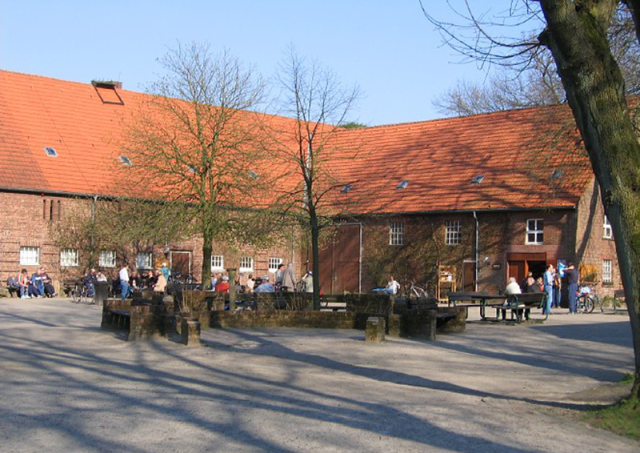 Hauptgebäude der Umweltpädagogische Station Heidhof mit Besucherinnen auf dem Hof