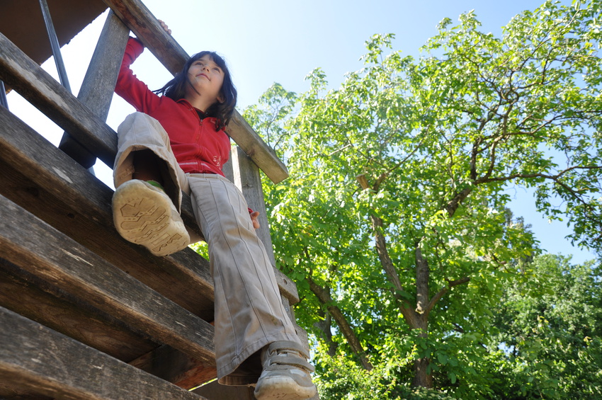 Mädchen auf Klettergerüst am Waldspielplatz
