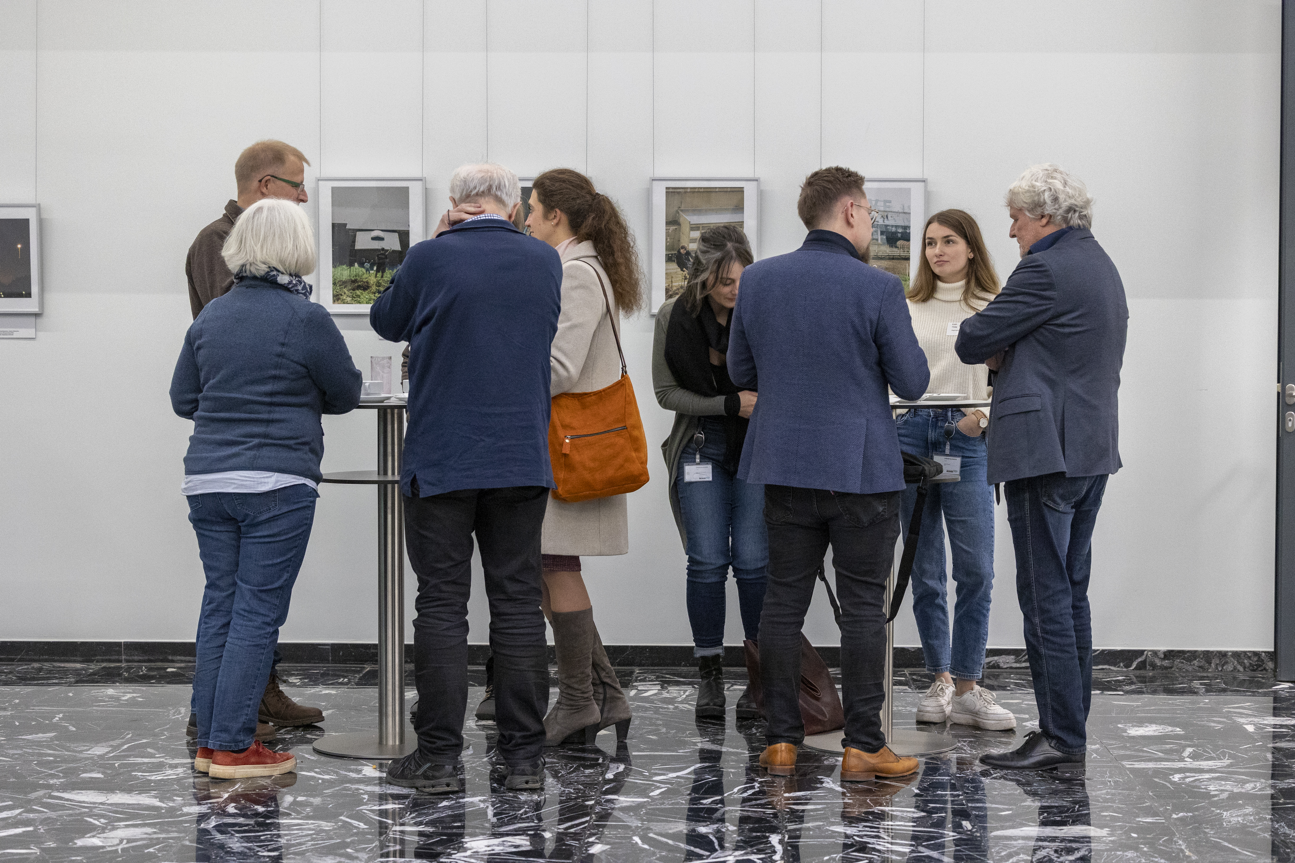 Zwei Menschengruppe um jeweils einen Stehtisch