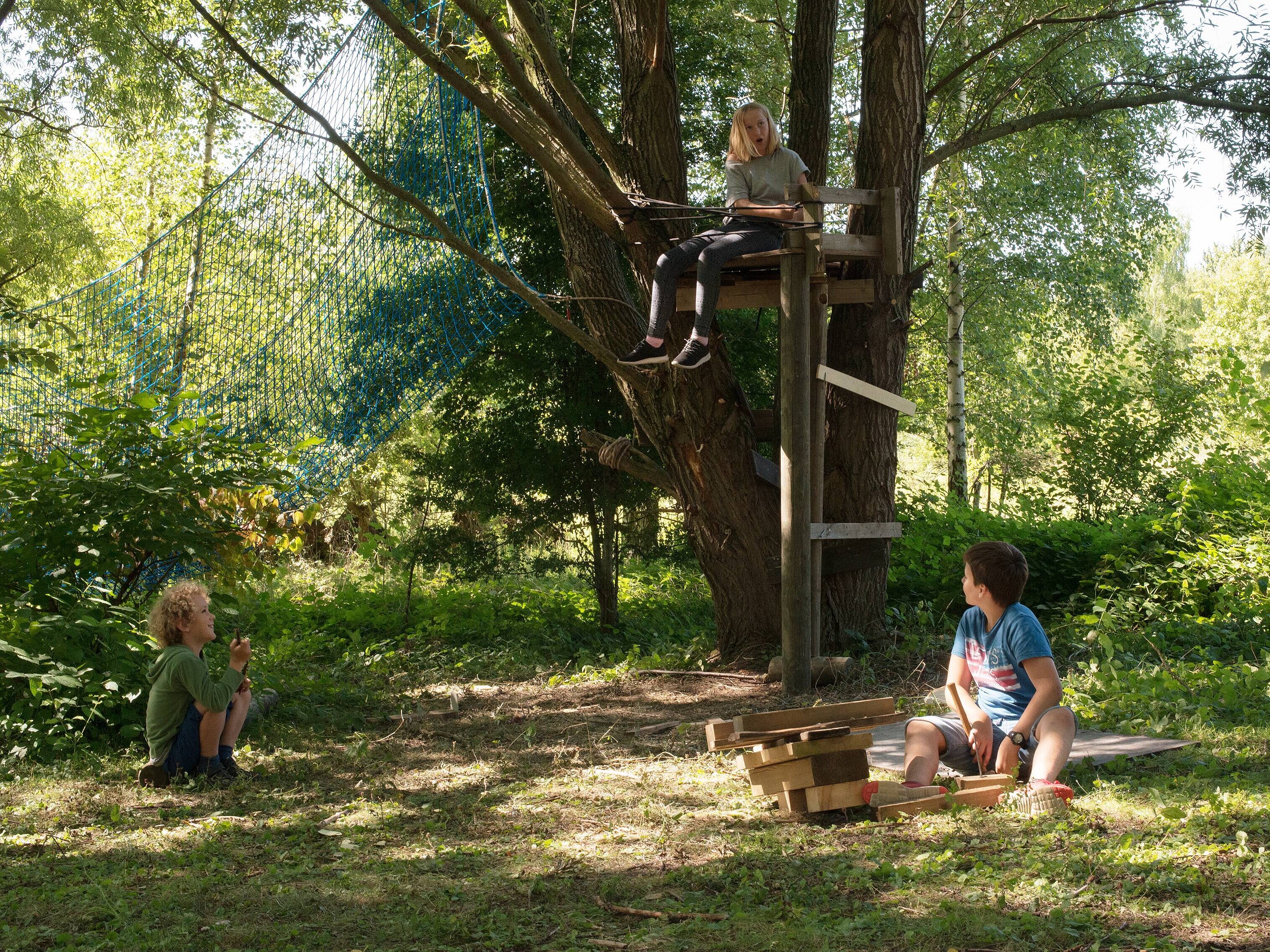 Naturerfahrungsraum mit Spielgeräten und Kindern
