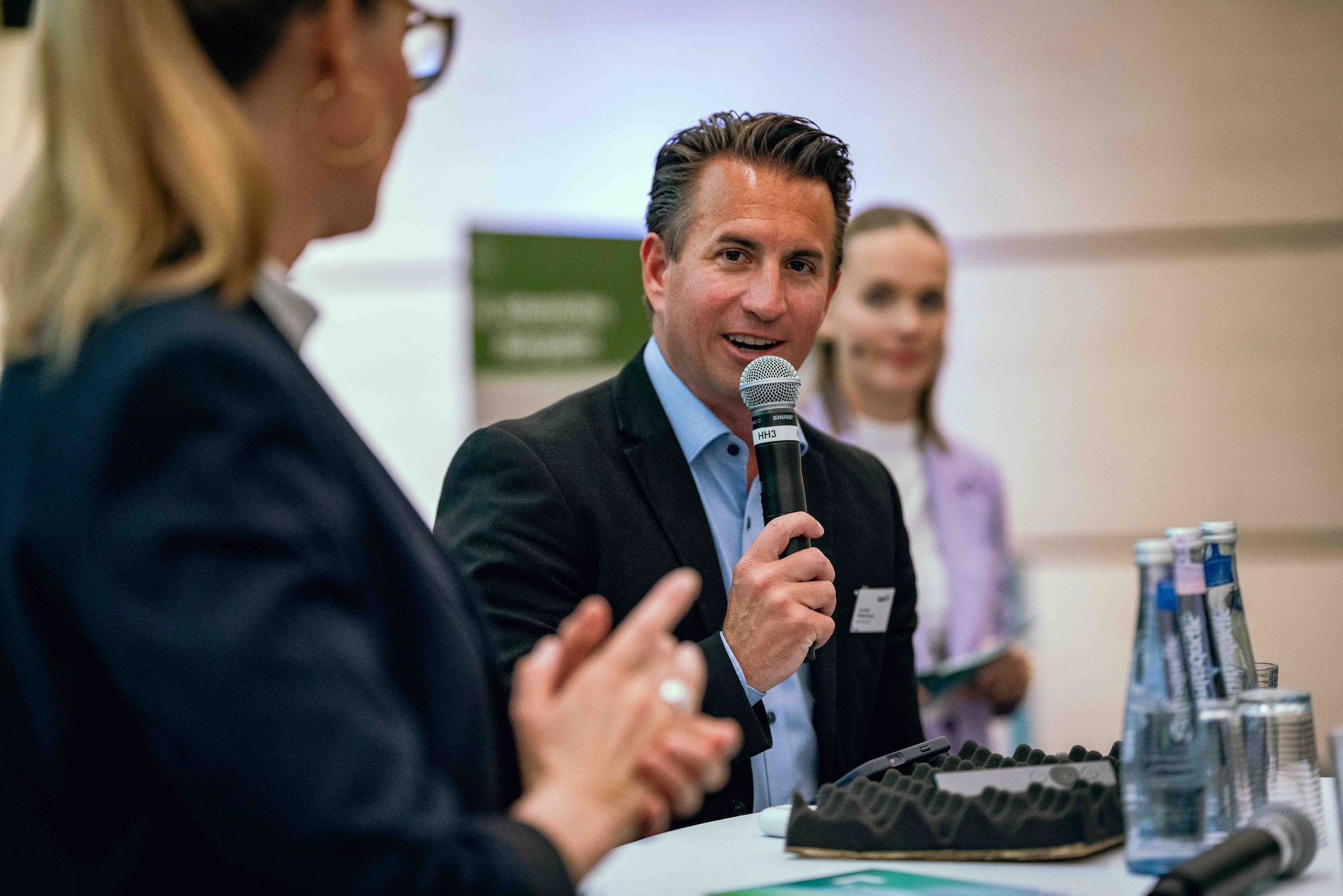 Christian Mildenberger, Geschäftsführer von NRW.Energy4Climate, steht auf der Bühne des Symposiums Grüne Infrastruktur und hält ein Mikrofon in der Hand.