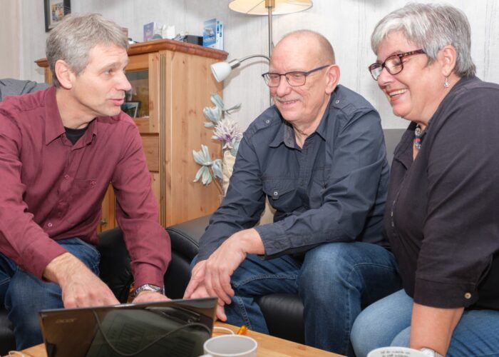 Berater informiert zwei Personen zur Gebäudesanierung.