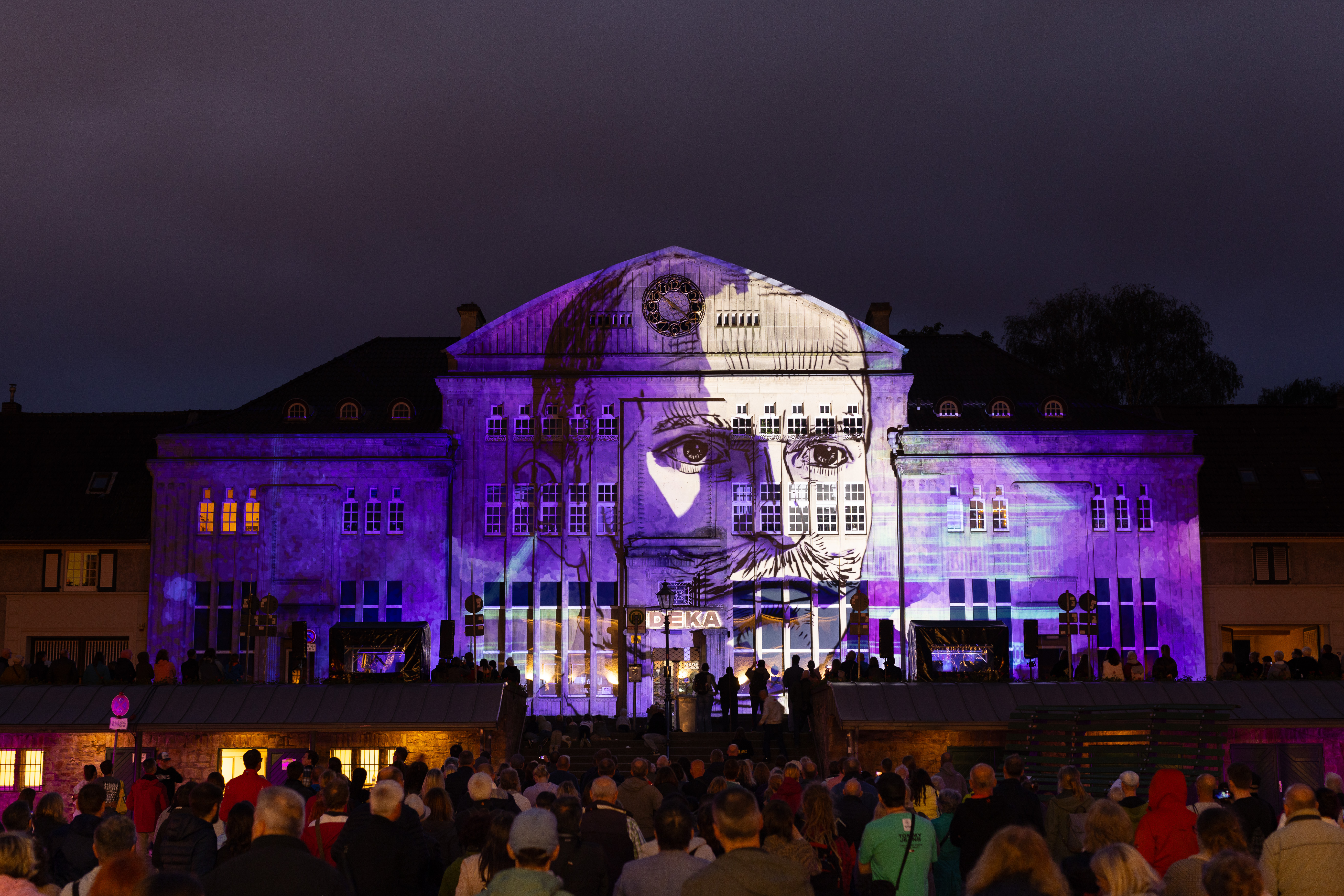 Ein altes Gebäude auf dem Marktplatz der Margarethenhöhe wird anhand einer Lichtinstallation beleuchtet.