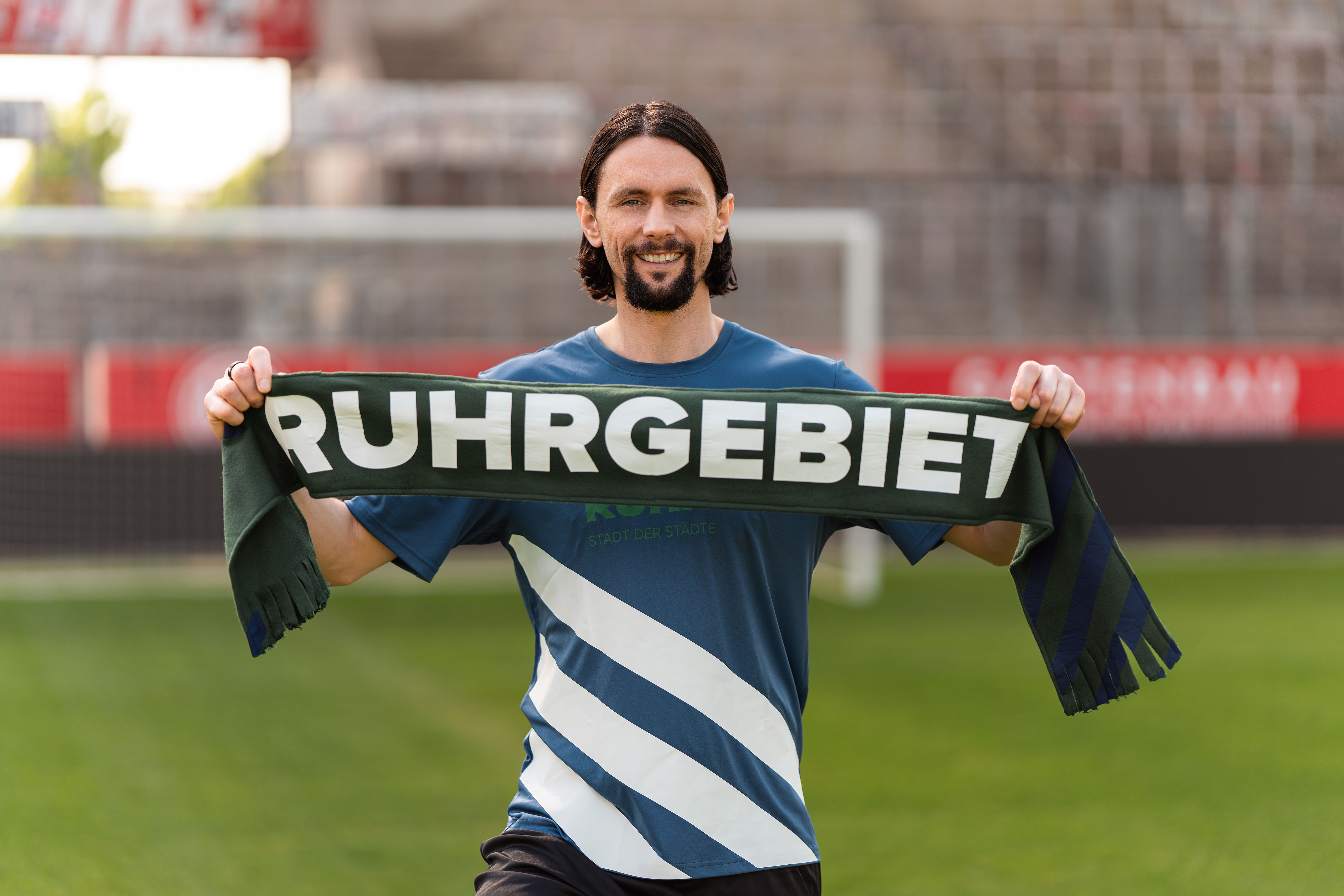 Neven Subotic hält einen Schal in den Händen mit der Aufschrift Ruhrgebiet.