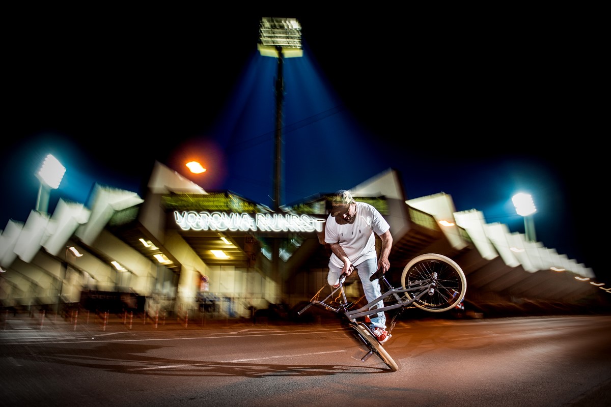 BMX-Fahrer macht einen Trick vor dem Ruhrstadion in Bochum.