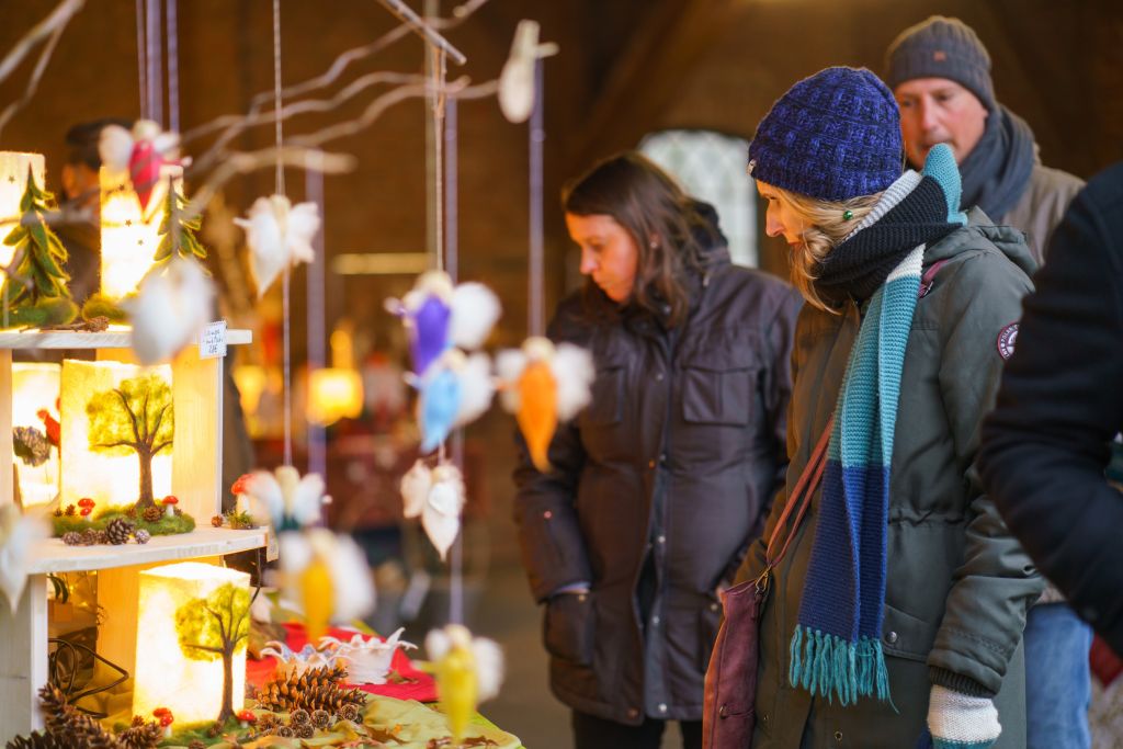 Menschengruppe steht vor einem Stand und bestaunt Weihnachtsdeko.