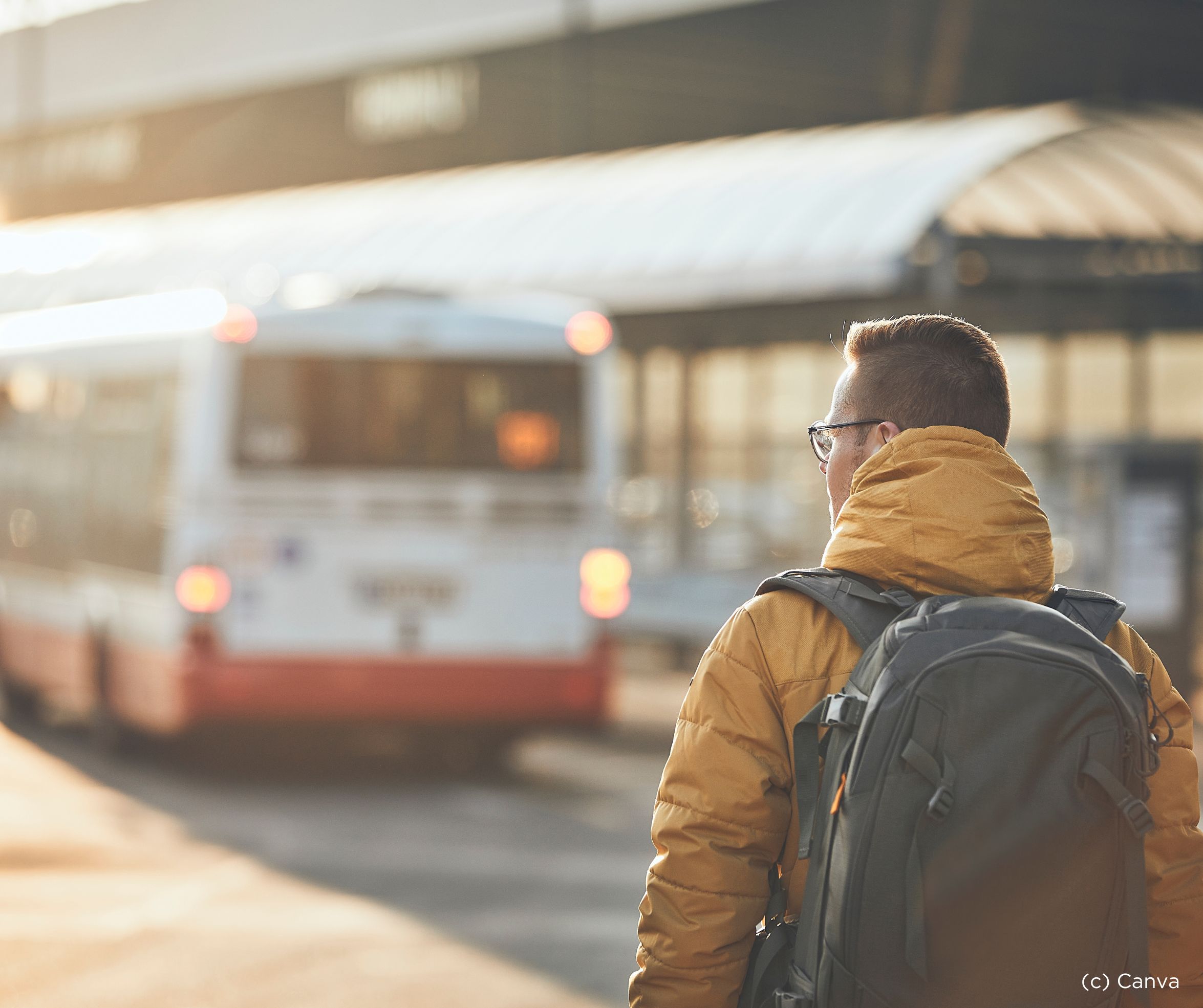 Ein Mensch wartet an einem Busbahnhof. 