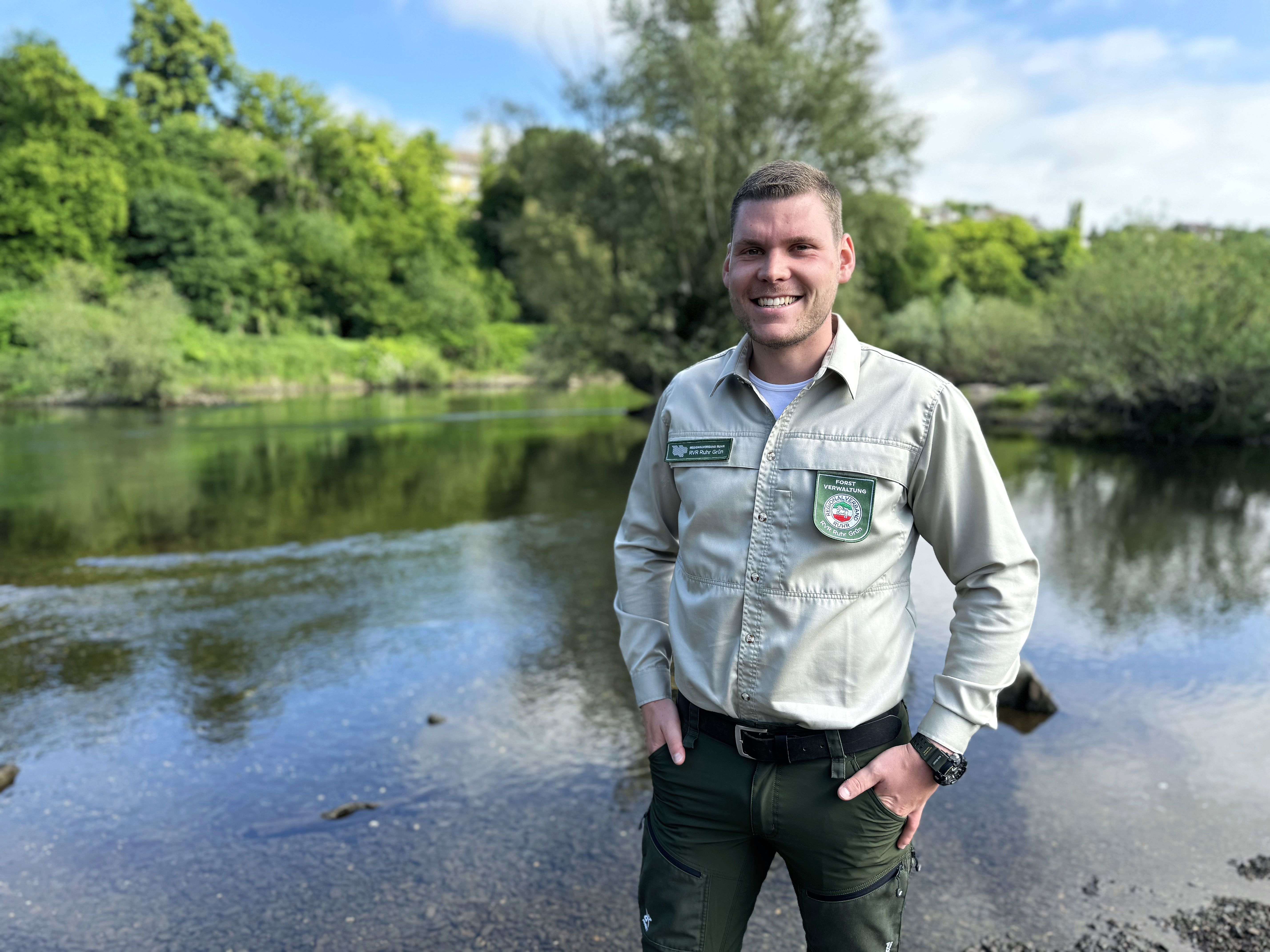 RVR-Ranger Marc Porsche steht am Ufer der Ruhr und lächelt in die Kamera.