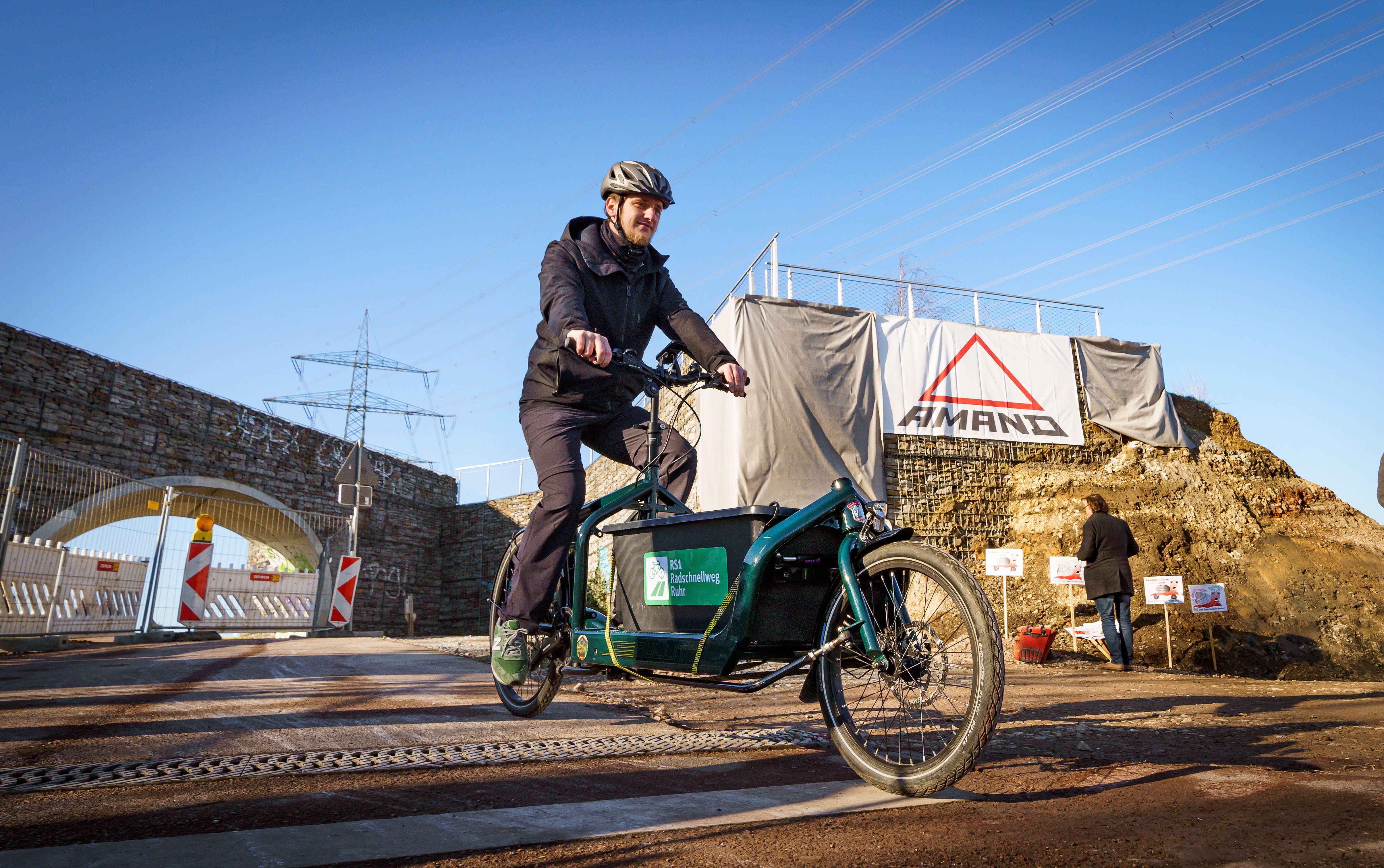 Robin Schmidt von der PIA Mülheim testet mit dem Lastenrad den Radweg an der Baustelle für die Brücke über den Berthold-Beitz-Boulevard in Essen.