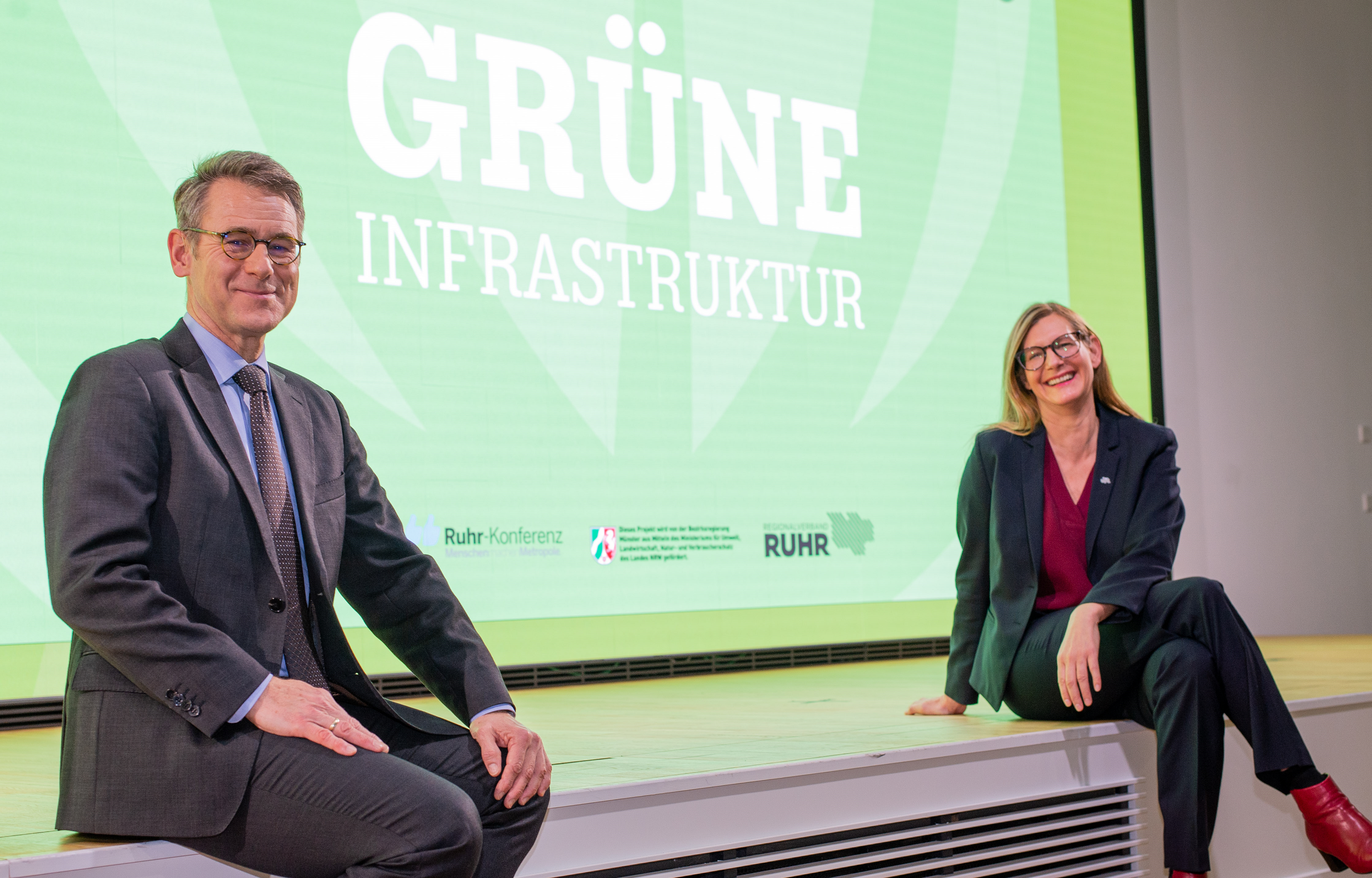 Zwei Personen sitzen auf der Bühne