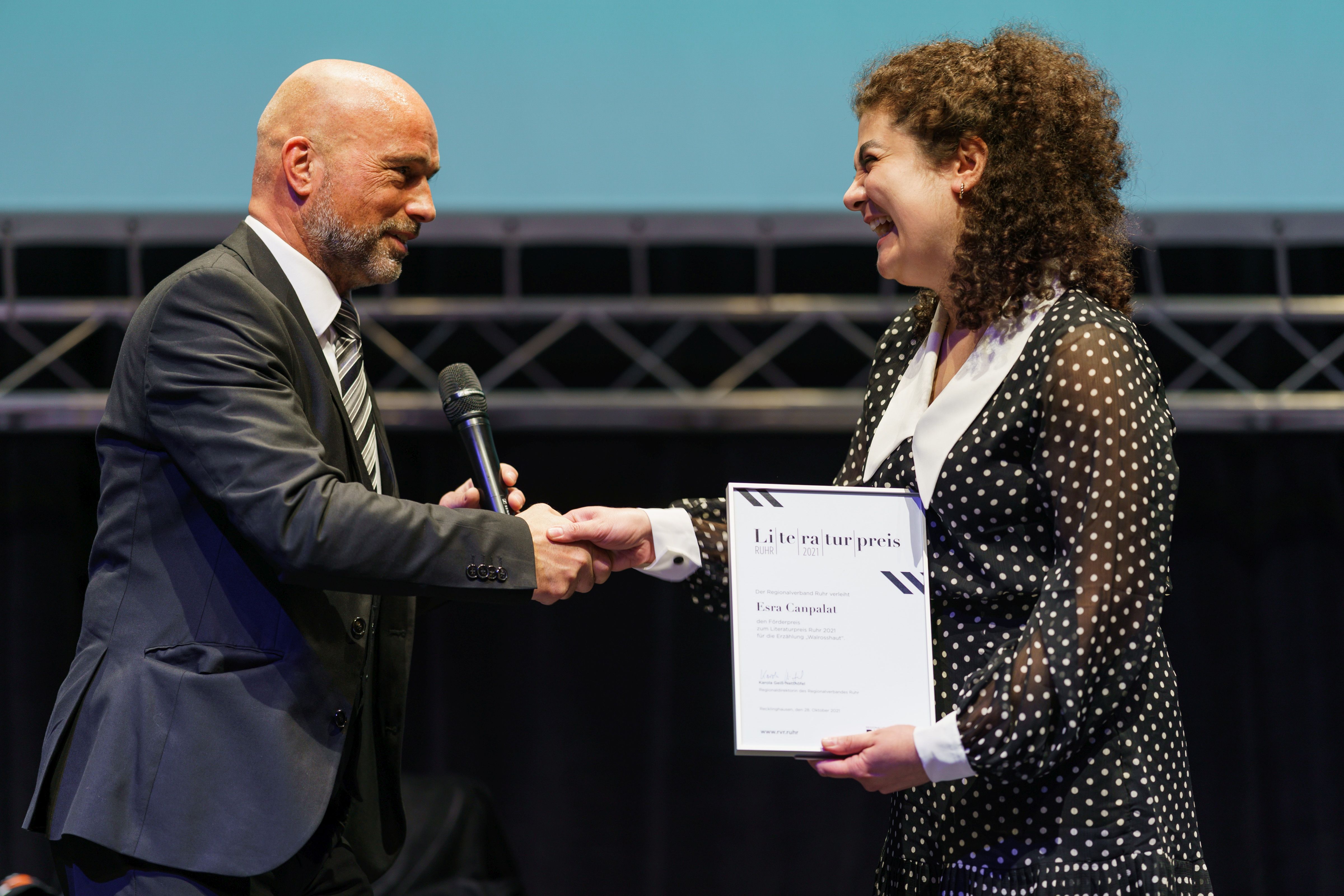 Jörg Obereiner, Vorsitzender des RVR-Kulturausschusses, übergibt den Förderpreis des Literaturpreises Ruhr an Esra Canpalat.