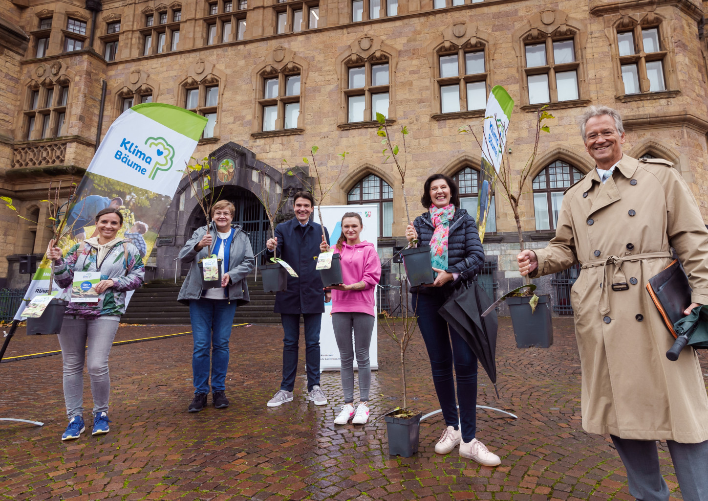 Personen mit Pflanzbäumen auf dem Rathaus-Platz in Recklinghausen