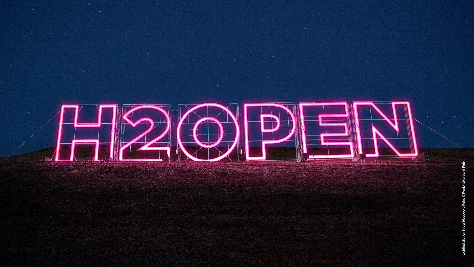 Große leuchtende Buchstaben, die das Wort H2OPEN bilden.