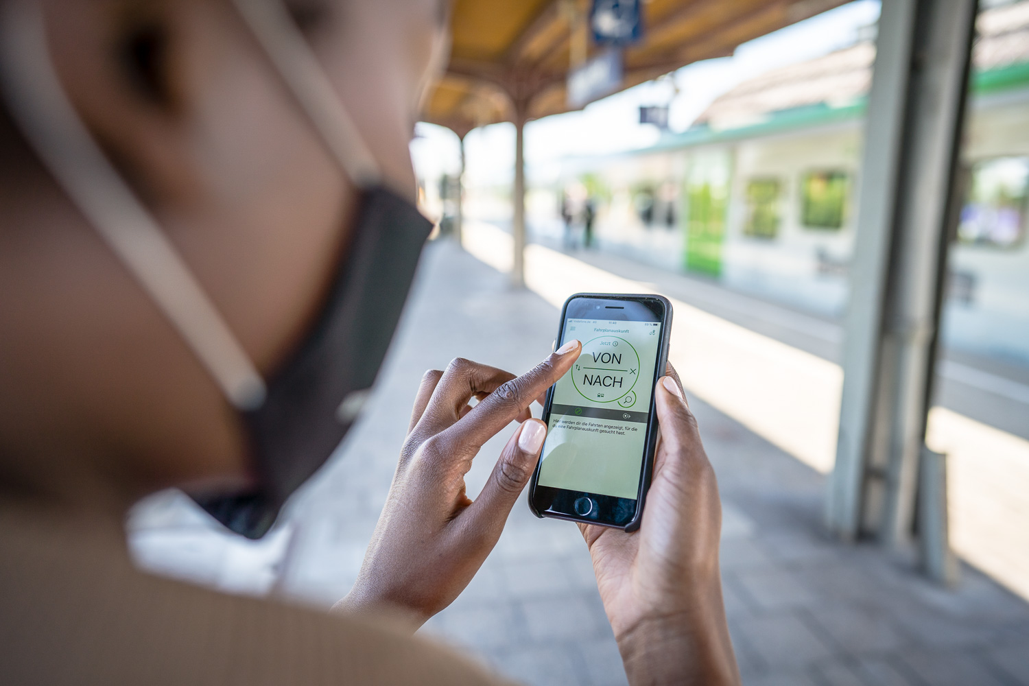 Frau blickt auf die VRR-App in ihrem Smartphone.