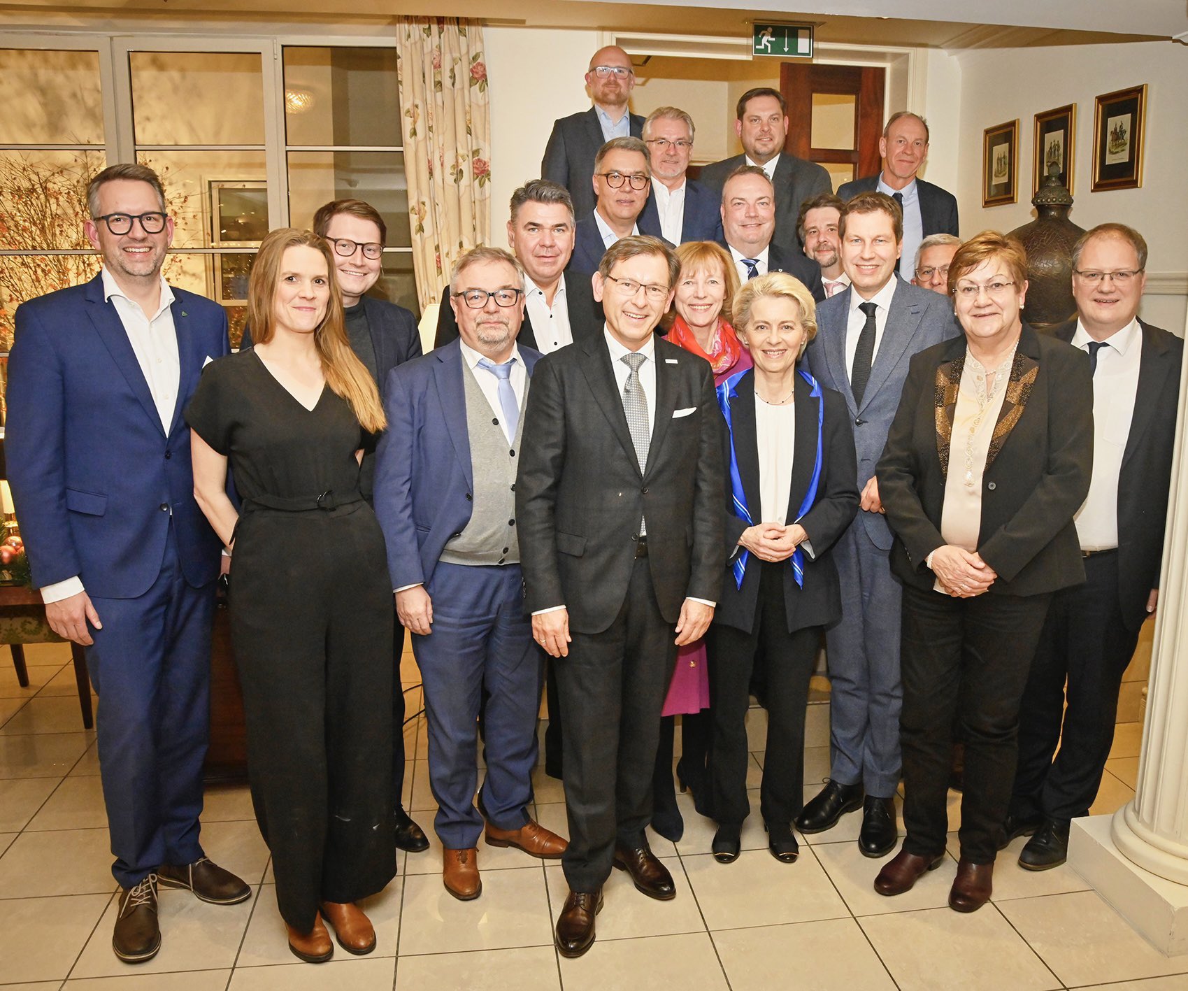 19 Personen stehen eng zusammen.