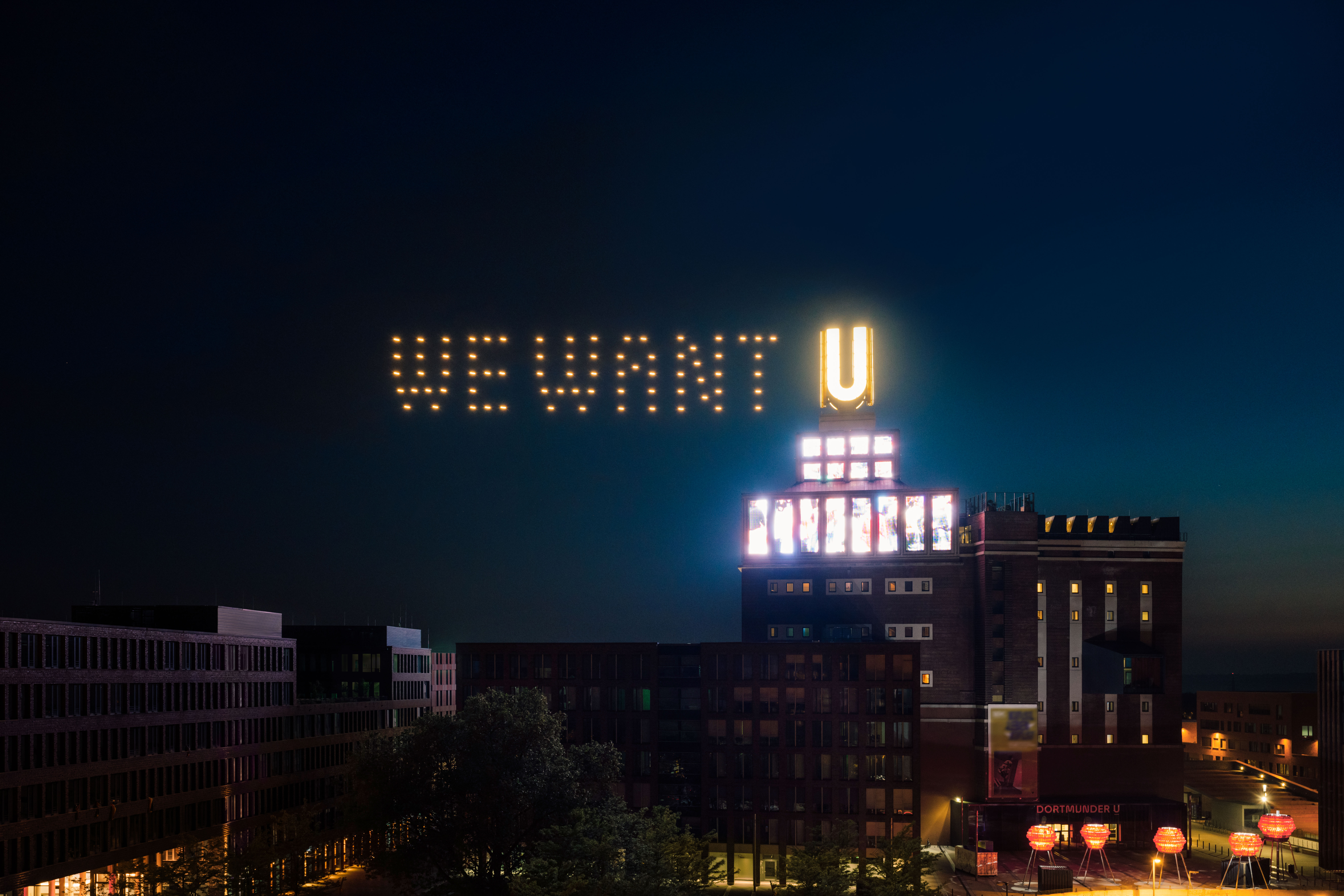 Dortmunder U bei Nacht mit leuchtenden Drohnen