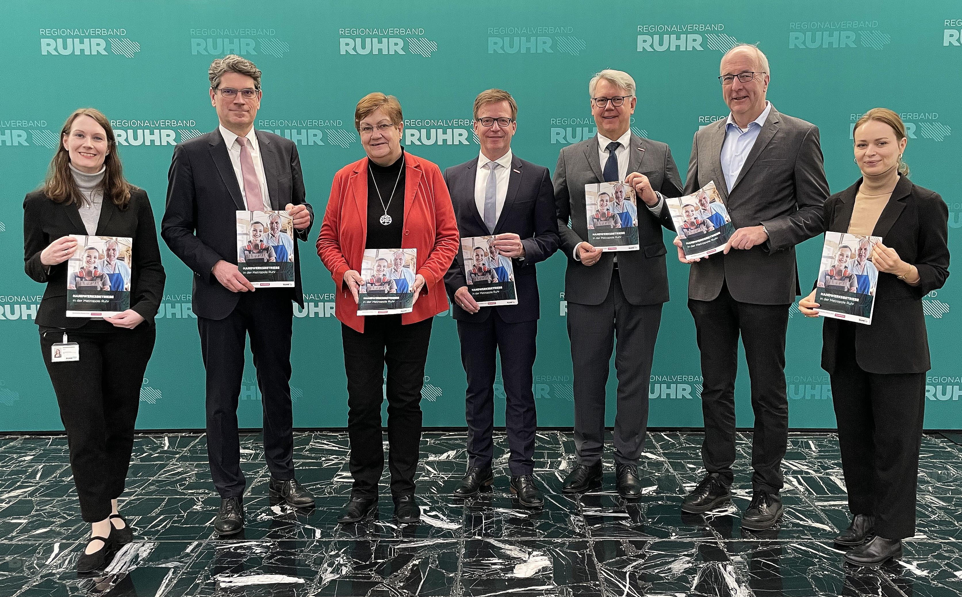 Gruppenfoto mit allen Beteiligten vor der RVR-Logo-Wand.