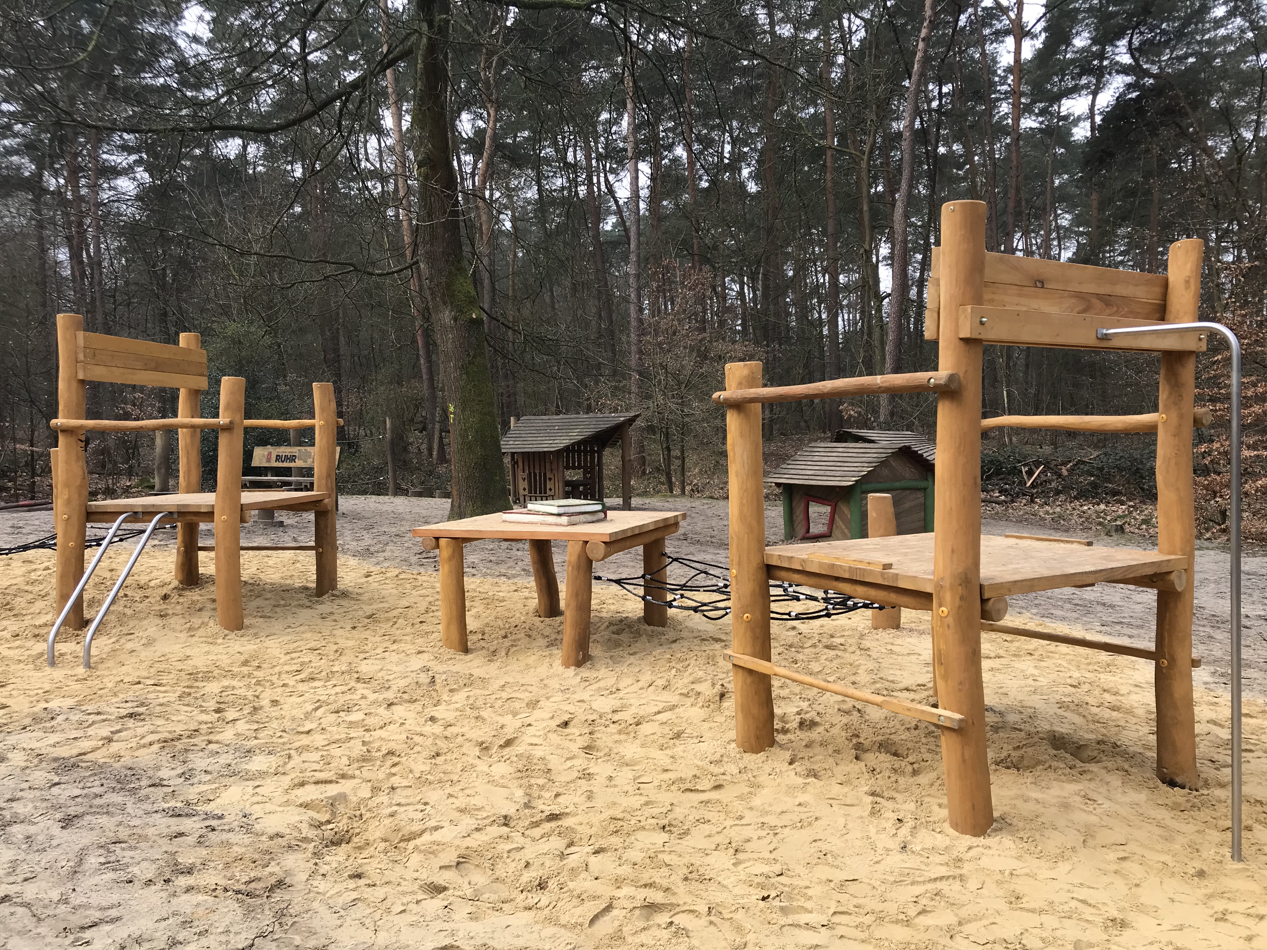 Riesige Holzstühle auf einem Spielplatz.