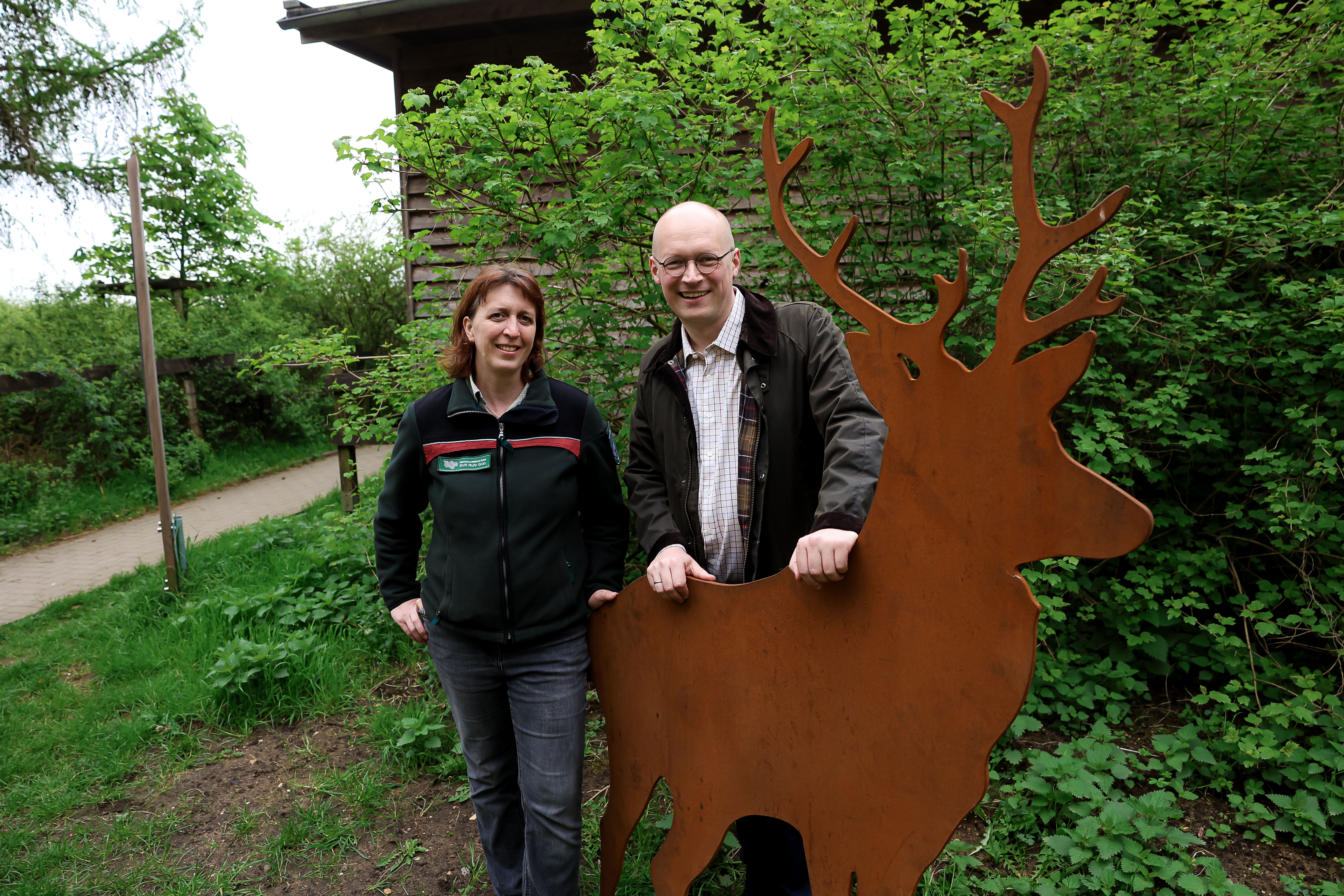 Stefan Kuczera (RVR-Beigeordneter Planung) und Juliane Saebel (Stellvertretende Betriebsleiterin von RVR Ruhr Grün) am Perspektivwechsel-Standort in Schermbeck. Sie stehen hinter einer Hirschfigur.