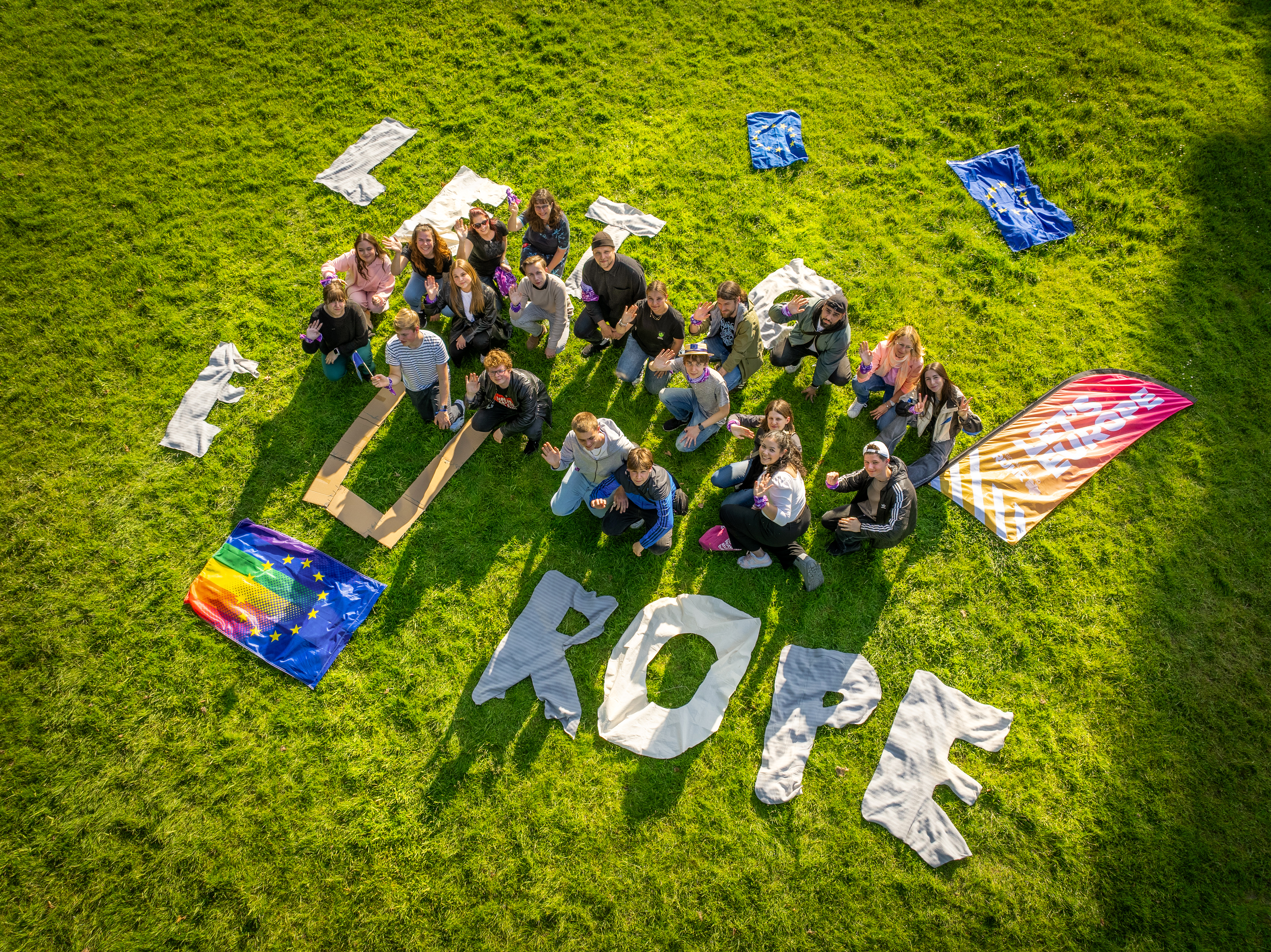 Jugendliche formen mit Buchstaben aus Stoff und Pappe den Slogan "Let's Europe"