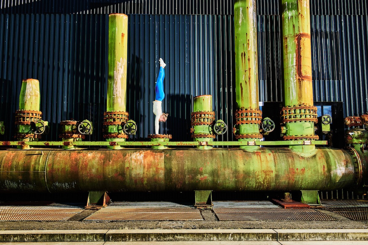Calisthenics-Sportlerin Annika Freyling aus Recklinghausen zeigt ihre Skills vor imposanter Industriekulisse. 