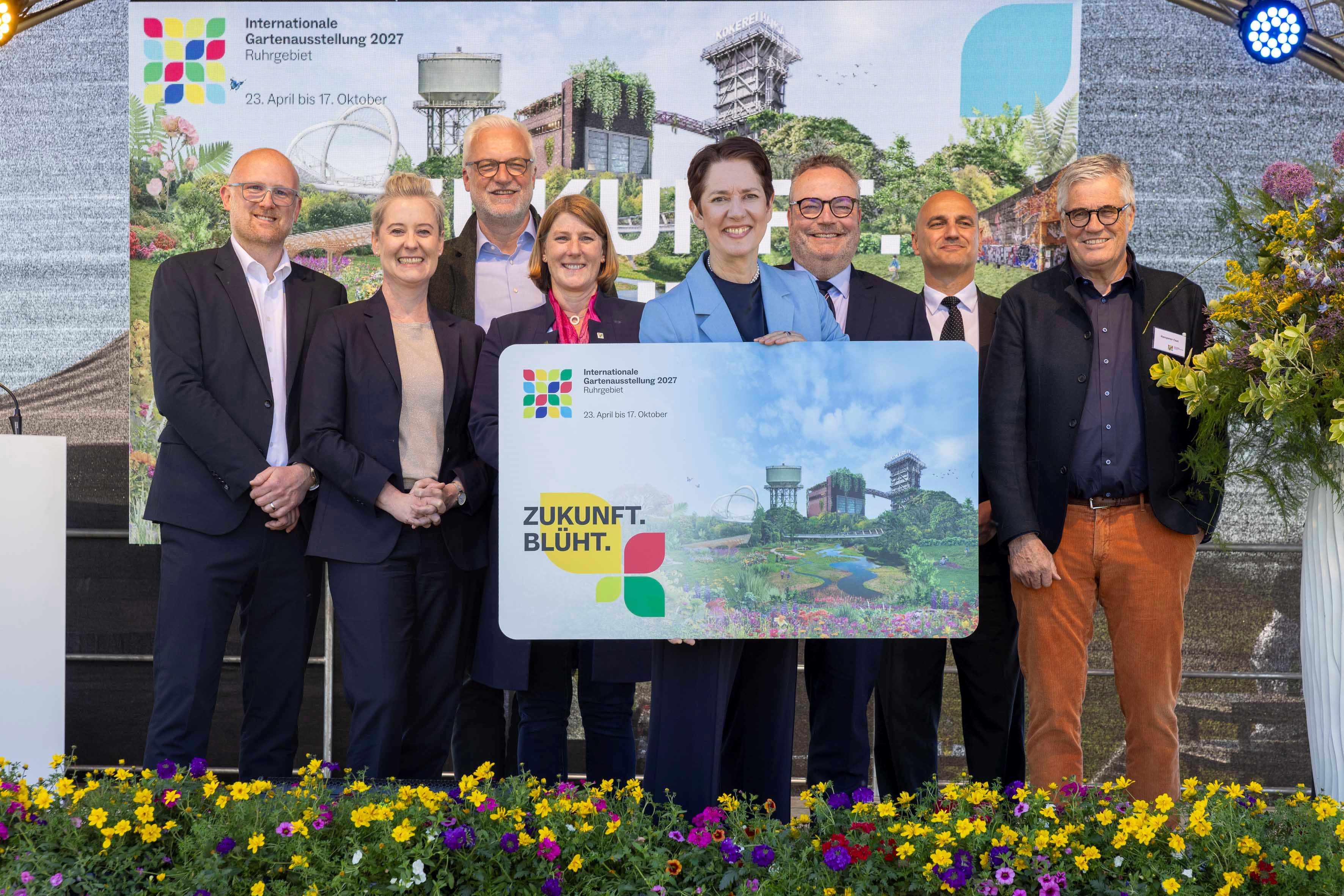 NRW-Landwirtschaftsministerin Silke Gorißen zeigt eine große Dauerkarte der IGA in die Kamera. 